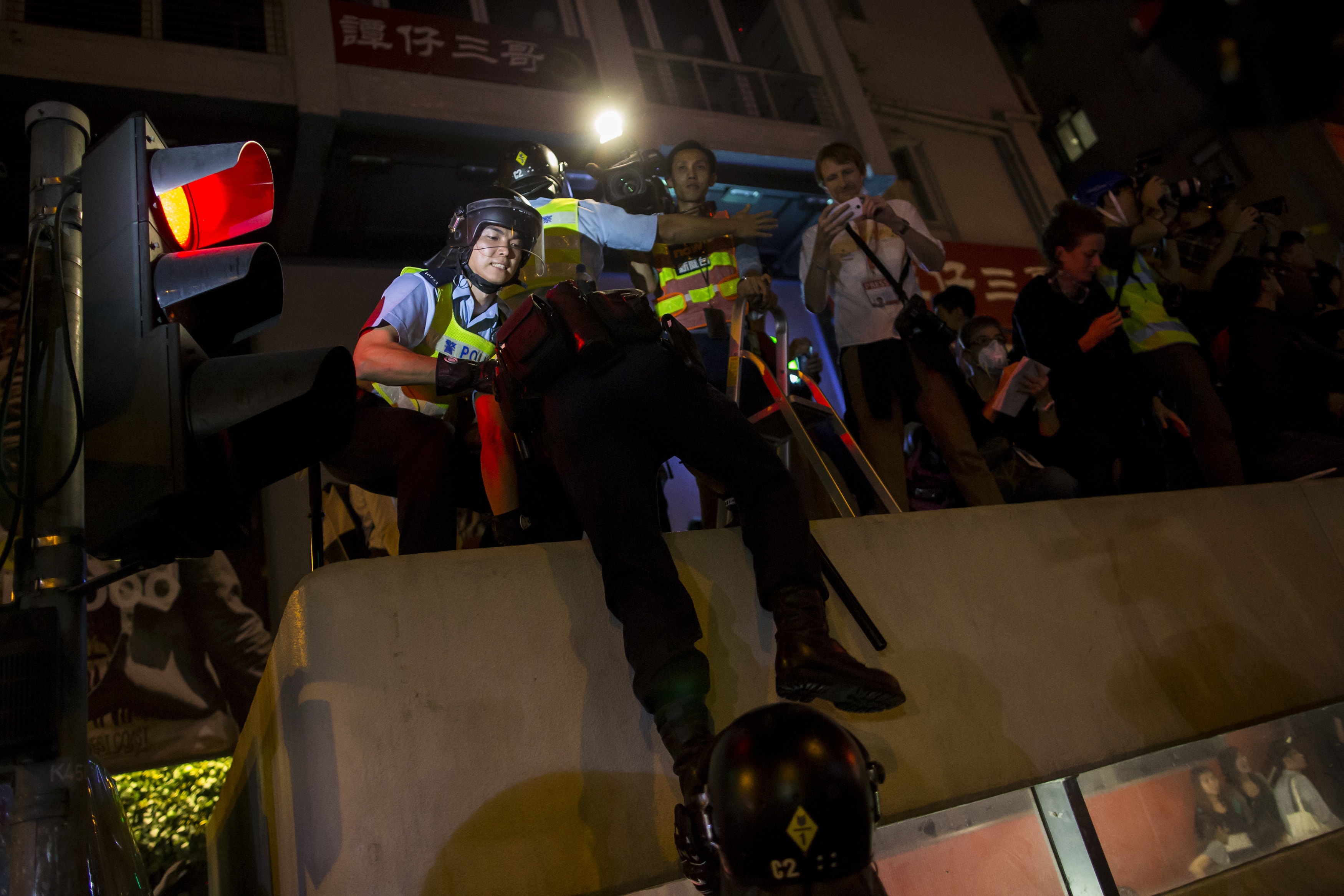 Riot police climb up to the top of a Mass Transit Railway (MTR) train station to disperse reporters during a confrontation at Mong Kok shopping district in Hong Kong, early 29 November 2014, REUTERS/Tyrone Siu