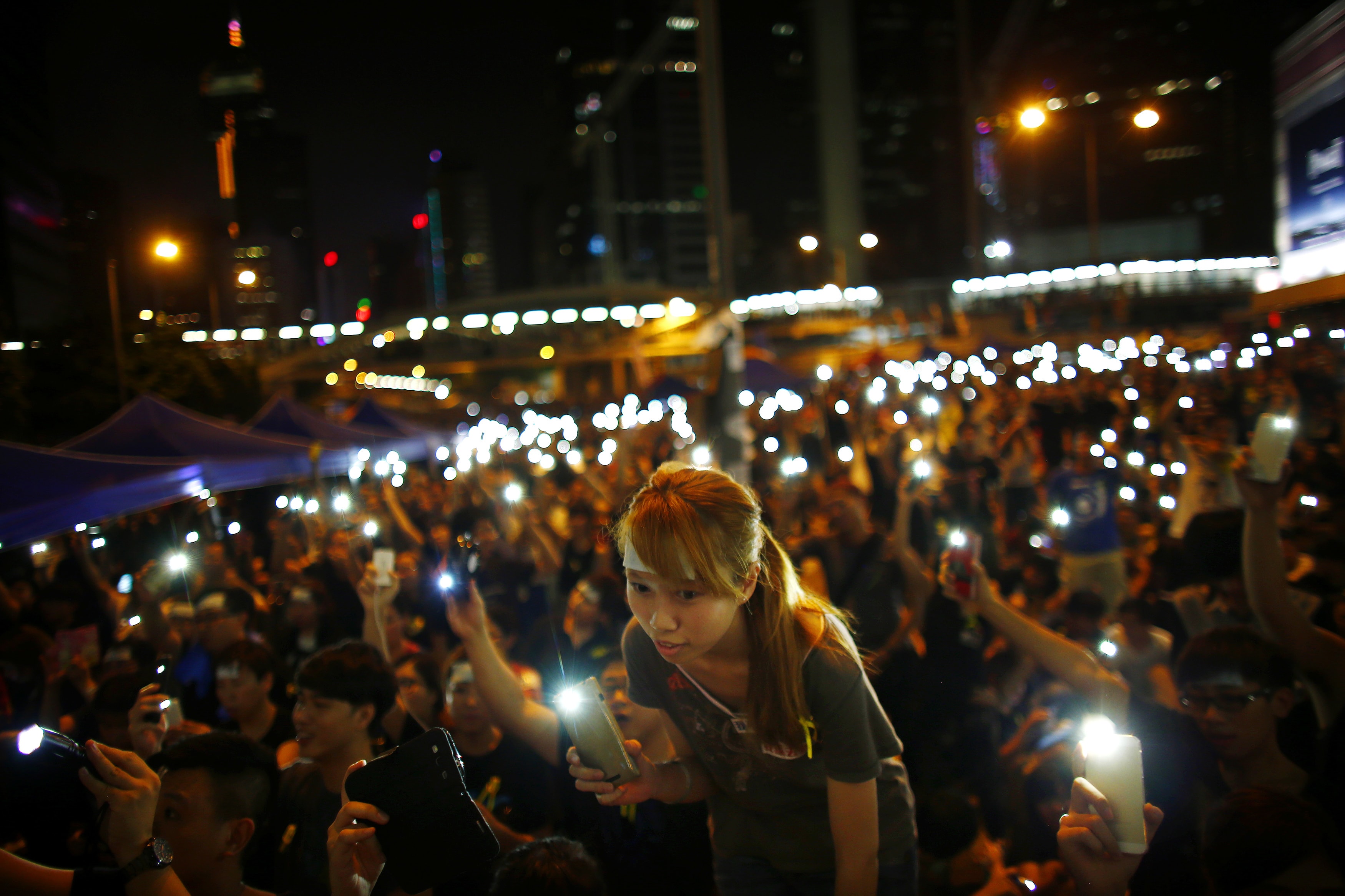 Protesters turn on their mobile phone flashlights as they block an area outside the government headquarters building in Hong Kong, 1 October 2014, REUTERS/Carlos Barria