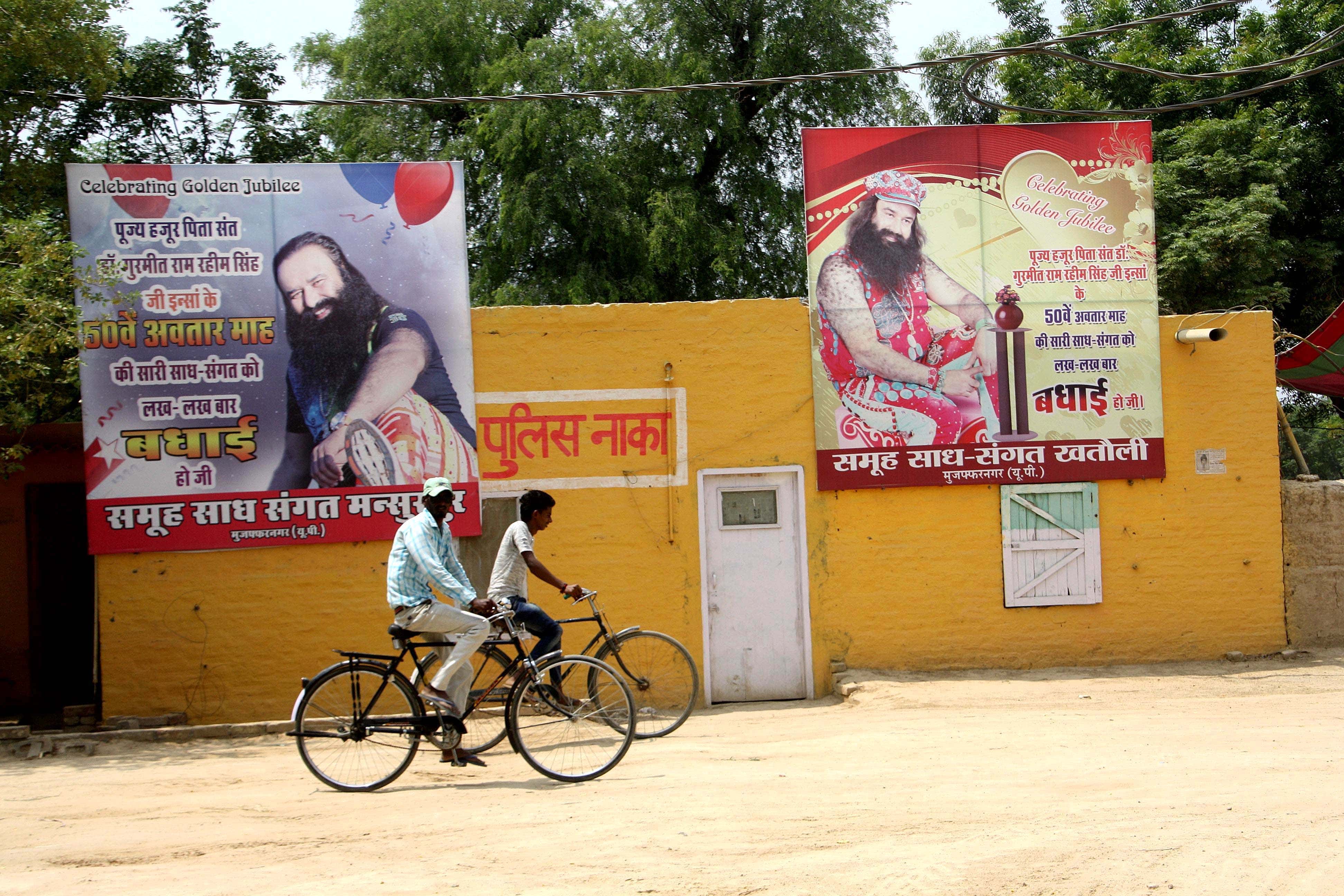 Posters depicting guru Gurmeet Ram Rahim Singh are displayed near a police post, in Sirsa, India, 28 August 2017, Manoj Dhaka/Hindustan Times via Getty Images