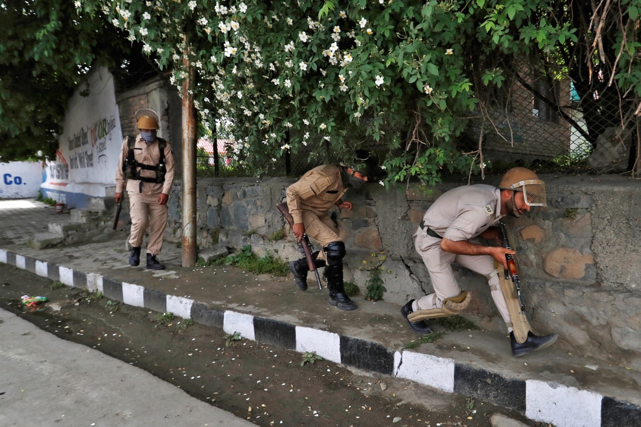 Police officers, one of whom is carrying a pellet gun, take cover from stone pelters during disturbances in Srinagar, Indian-administered Kashmir, 17 May 2017, REUTERS/Cathal McNaughton