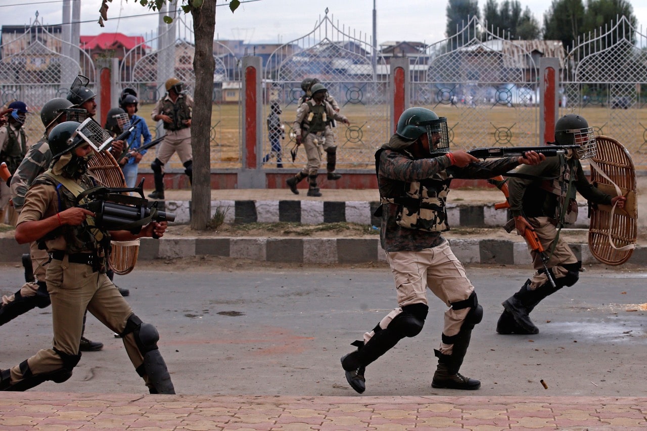 An Indian policeman aims a gun towards protesters during clashes after the Eid al-Adha prayers in Srinagar, 2 September 2017, REUTERS/Danish Ismail