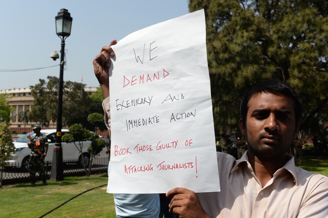 An journalist holds a placard during a protest near the Indian parliament sparked by outrage over the murder of Sandeep Sharma, in New Delhi, 27 March 2018, SAJJAD HUSSAIN/AFP/Getty Images