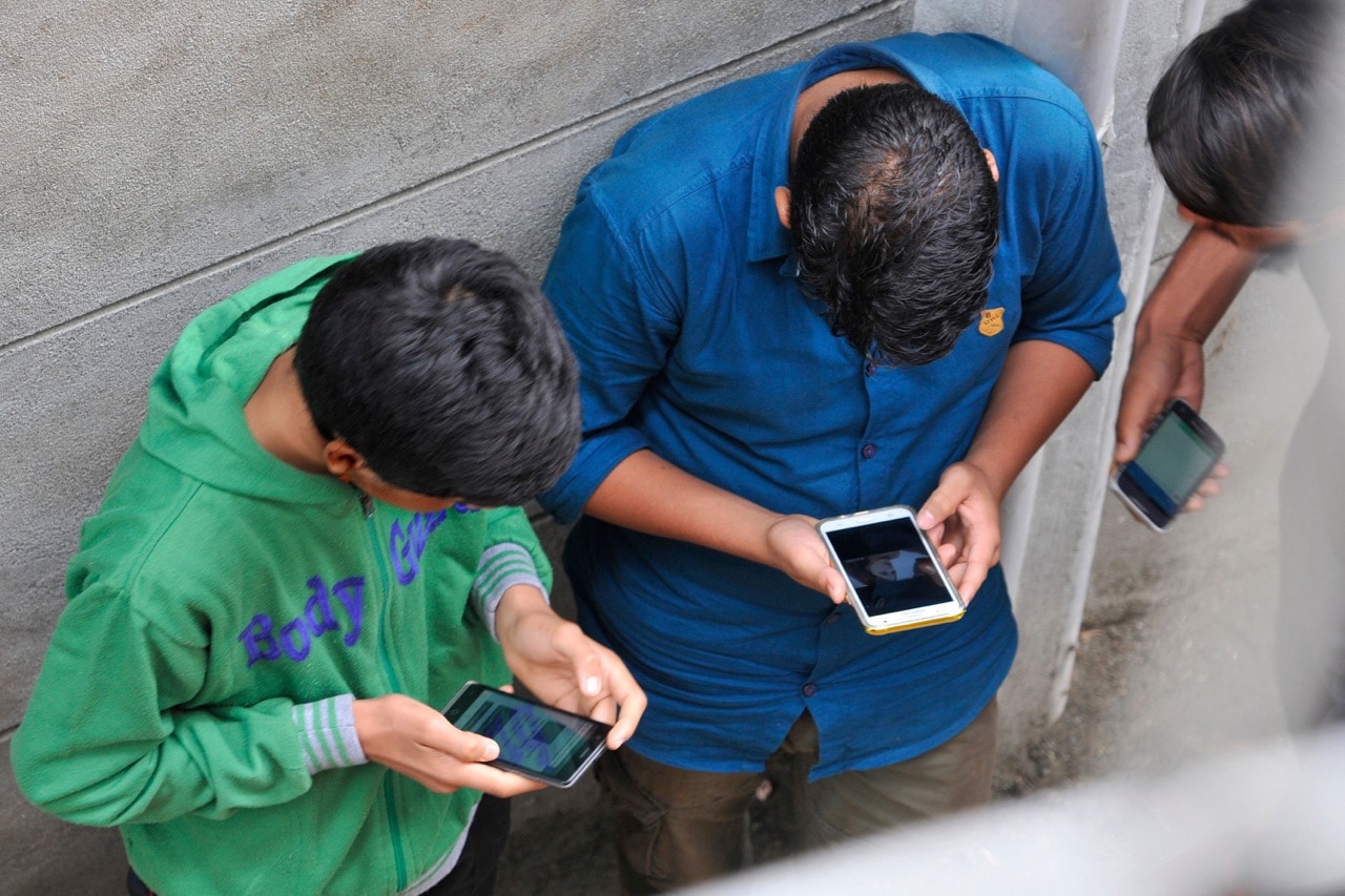Kashmiri boys surf the internet on their phones after hacking into a network during restrictions in a part of Srinagar, India, 27 August 2016, Waseem Andrabi/Hindustan Times via Getty Images