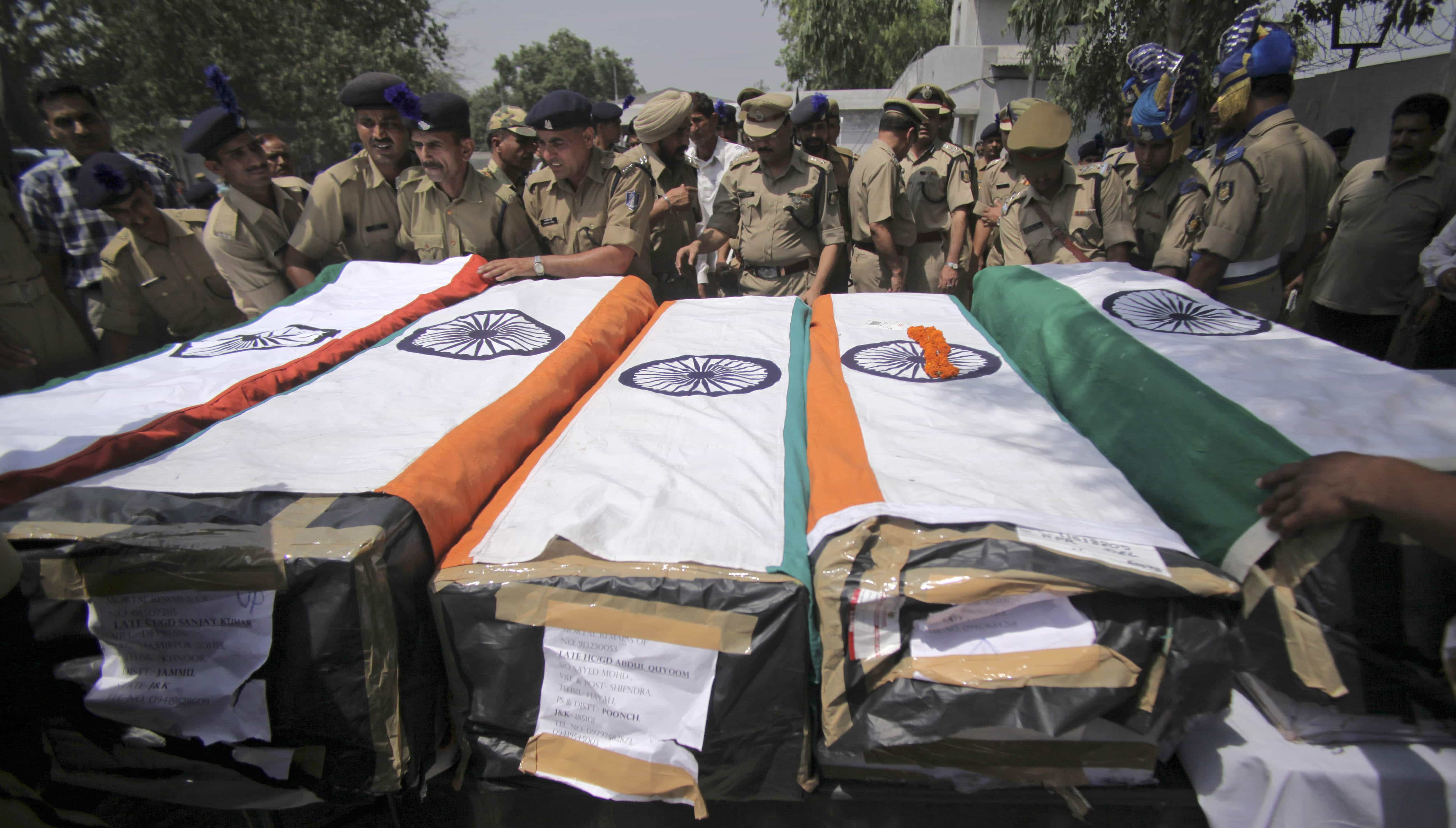 In this 19 May 2011 file photo, in Jammu, India officers arrange the coffins of paramilitary soldiers killed in a land mine explosion believed to have been set by Maoist rebels, AP Photo/Channi Anand