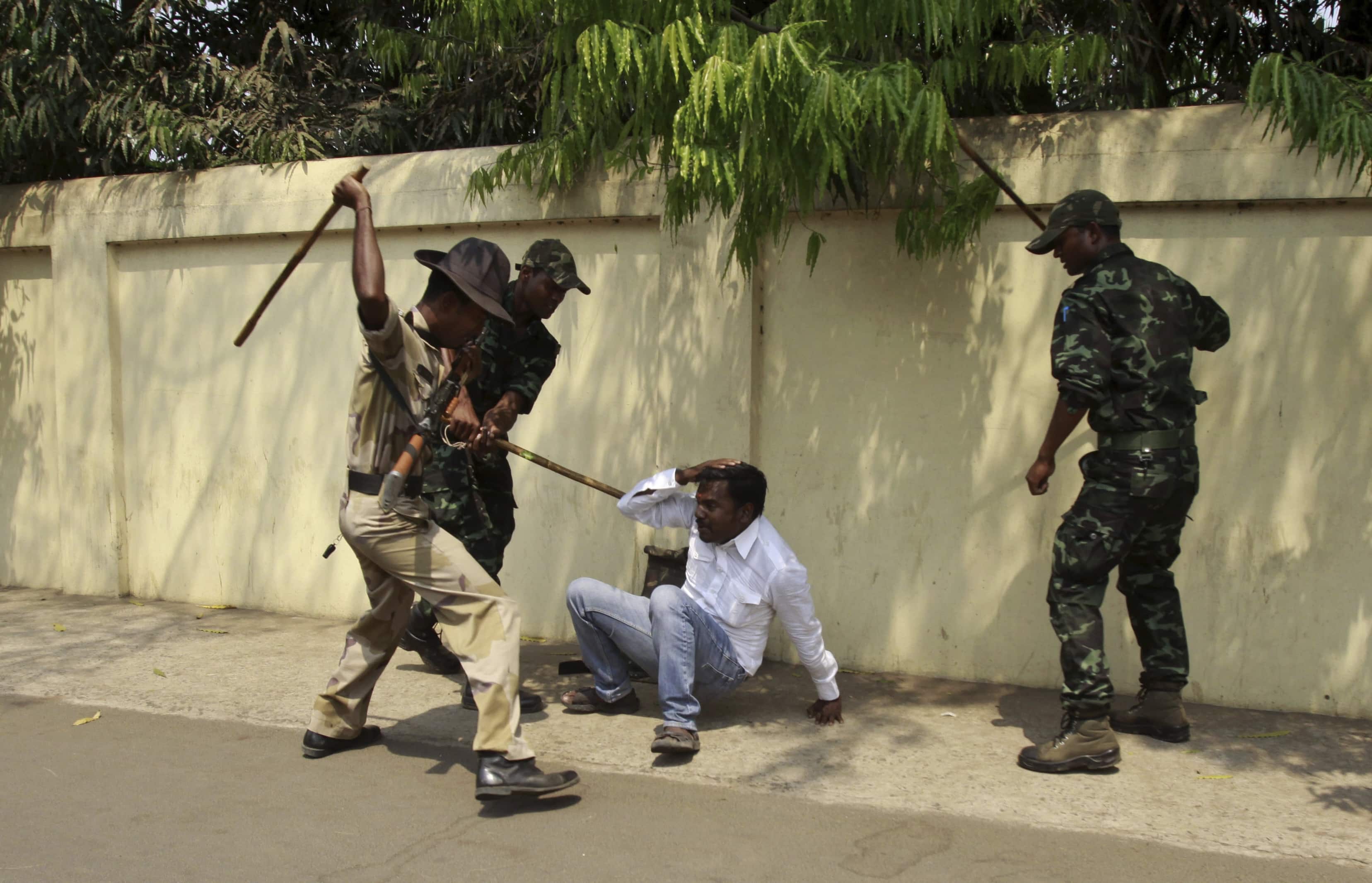 Indian policemen beat an opposition activist during a protest outside the Odisha state chief minister's office in Bhubaneswar, India, on 25 March 2013, AP/Biswaranjan Rout