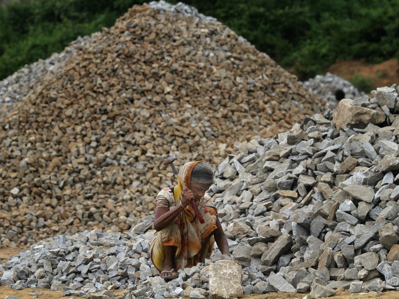 A labourer breaks stones on the outskirts of Gauhati, India, 5 June 2014, AP Photo/Anupam Nath