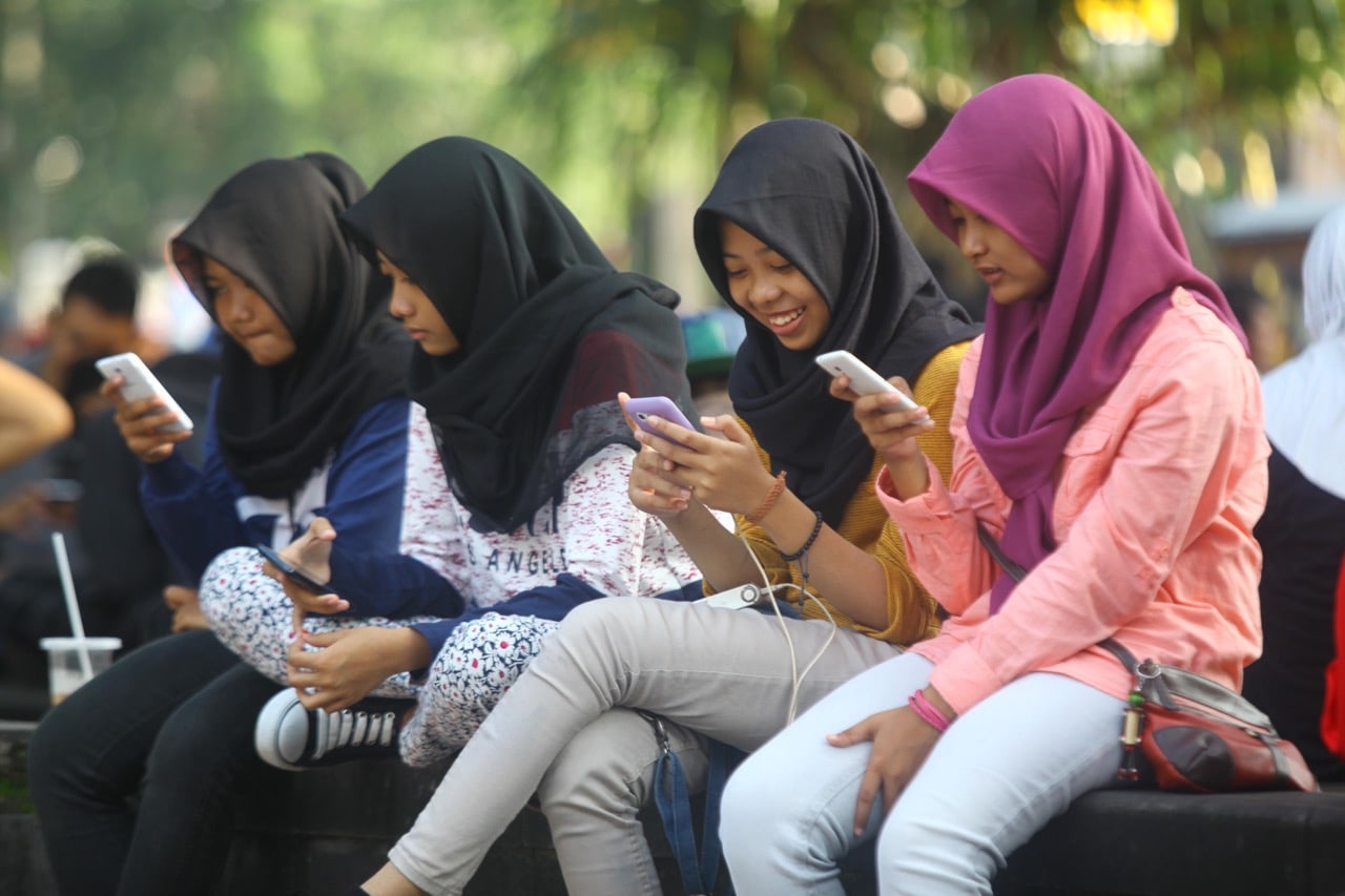 Young women on their cellphones in Surakarta, Indonesia, 17 July 2016, Solo Imaji / Barcroft Images / Barcroft Media via Getty Images