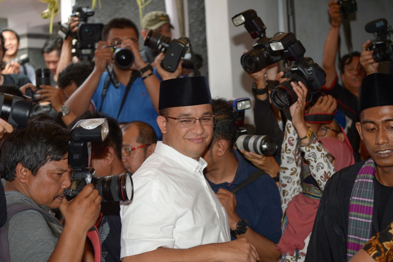 Candidate for Jakarta governor, Anis Baswedan (C) is surrounded by journalists as he arrives at a polling station in Jakarta, Indonesia, 19 April 2017, ADEK BERRY/AFP/Getty Images