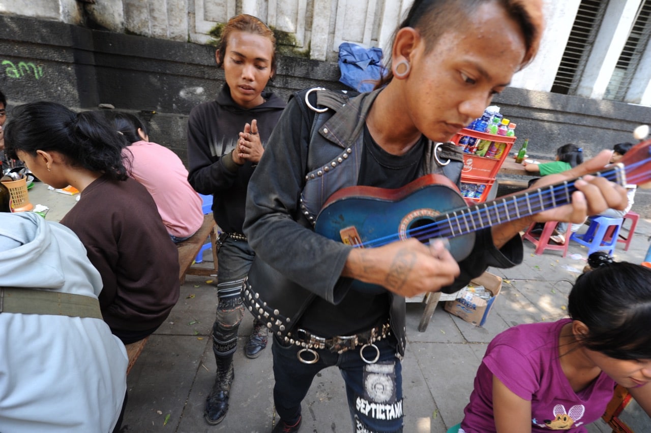 Indonesian street punk musicians play by sidewalk food stalls in Jakarta, Indonesia, 21 June 2010, ROMEO GACAD/AFP/Getty Images