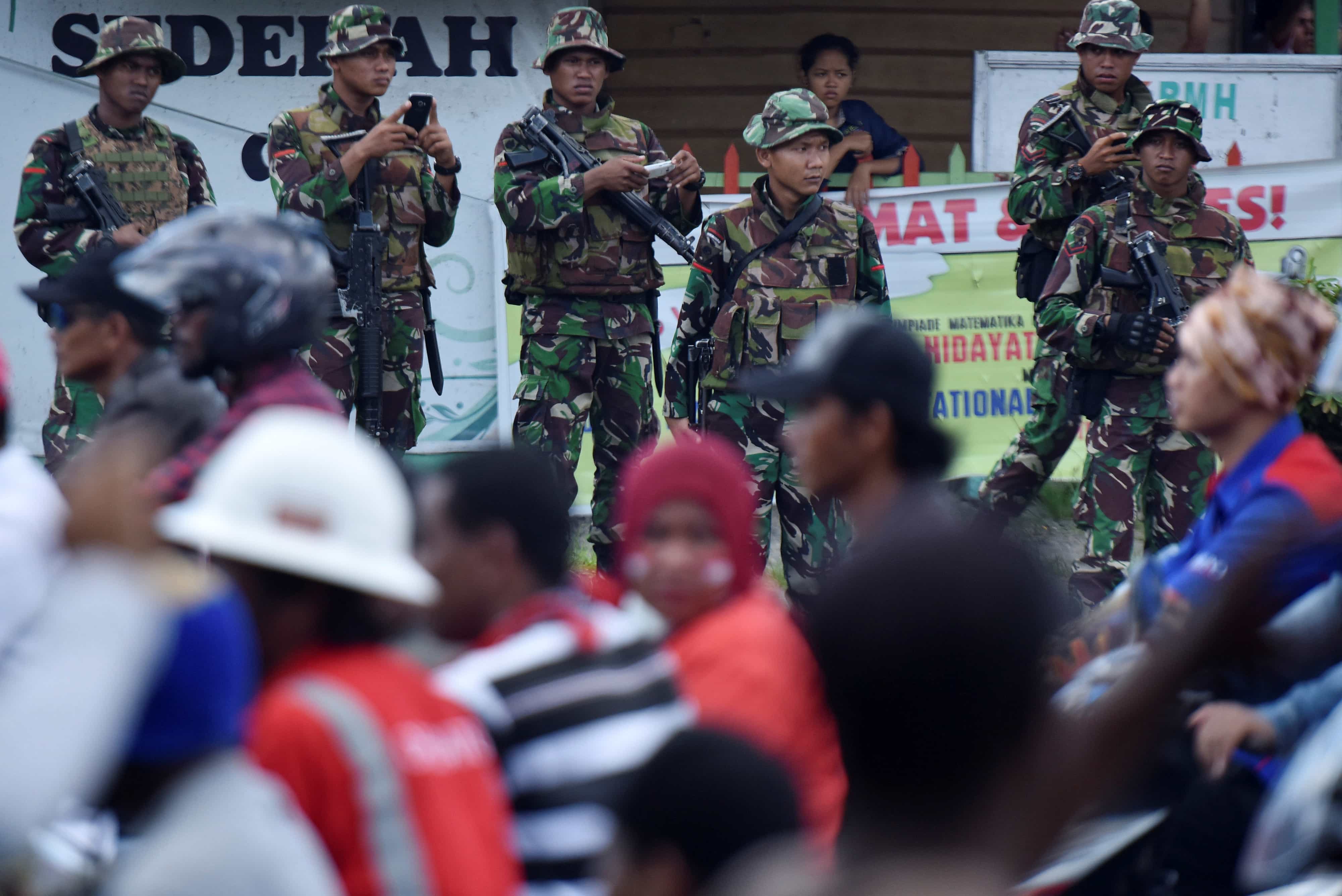Indonesian soldiers watch as workers and contractors from the PT Freeport mining company travel in a convoy during a rally commemorating May Day in Timika, Papua province, 1 May 2017 , Antara Foto/Wahyu Putro A/via REUTERS