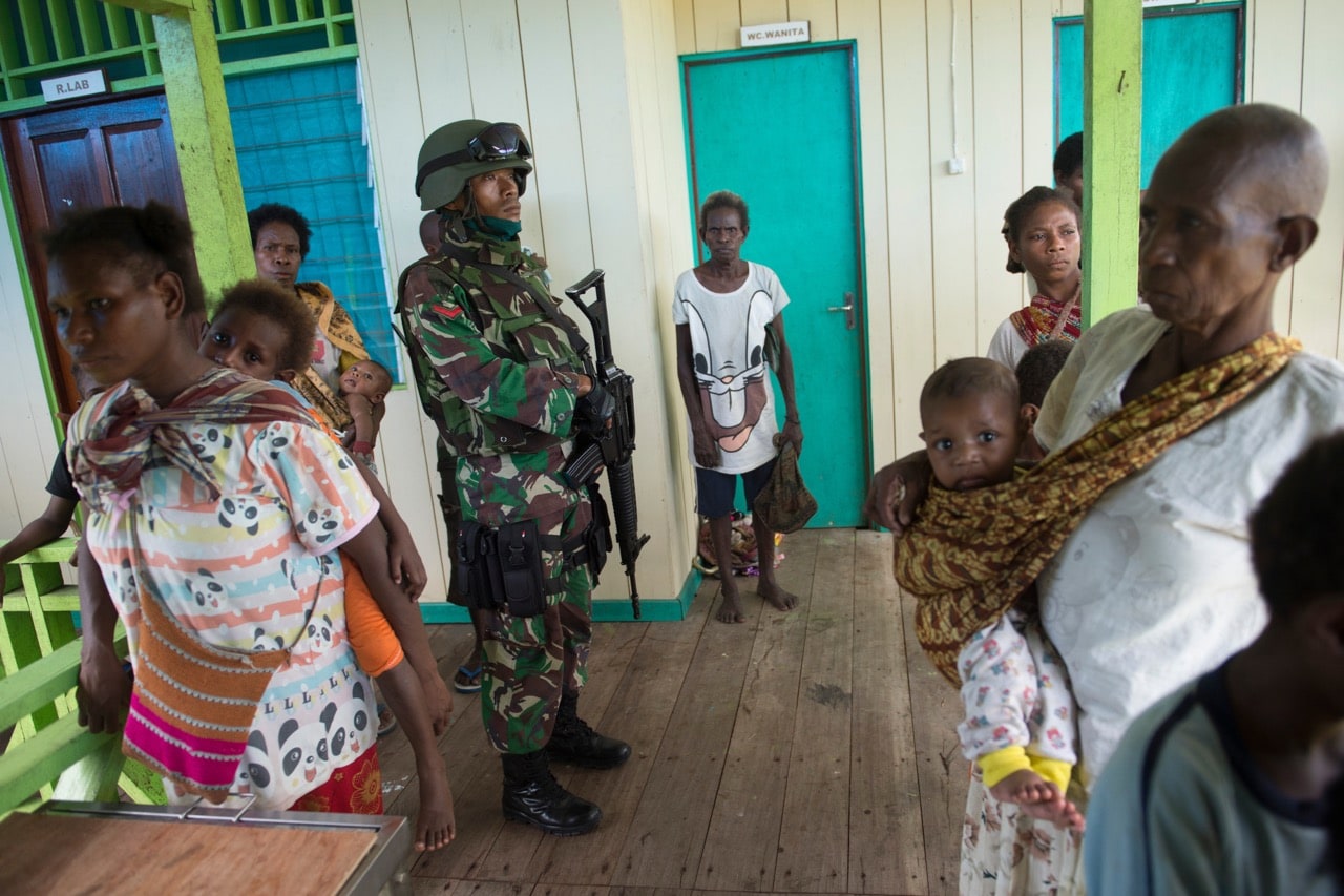 An Indonesian armed military officer stands guard at the local clinic during a measles and malnutrition outbreak, at Ayam village, Asmat district, Papua province, 26 January 2018, BAY ISMOYO/AFP/Getty Images