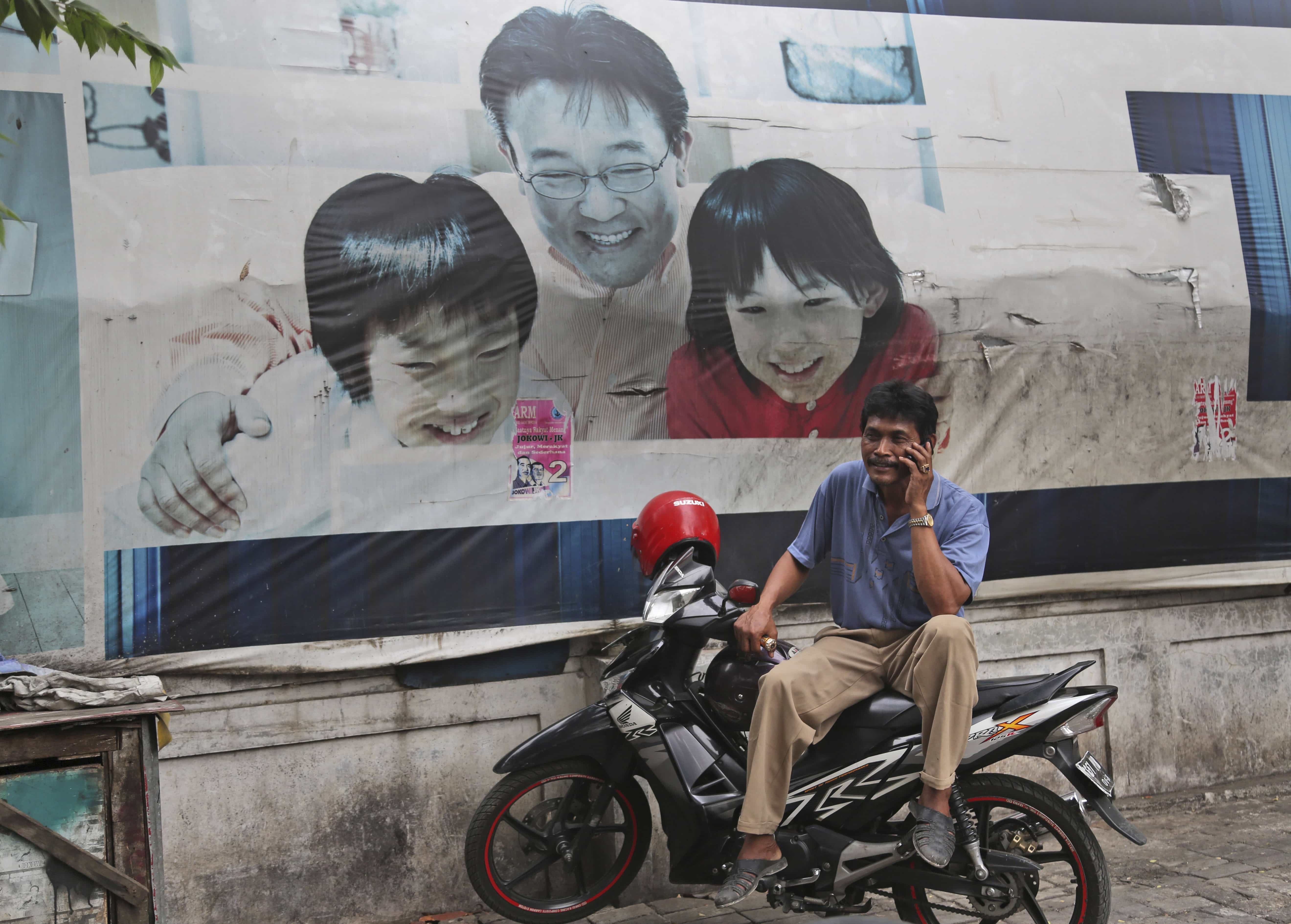 A man talks on his mobile phone in Jakarta, 30 October 2014, AP Photo/Tatan Syuflana