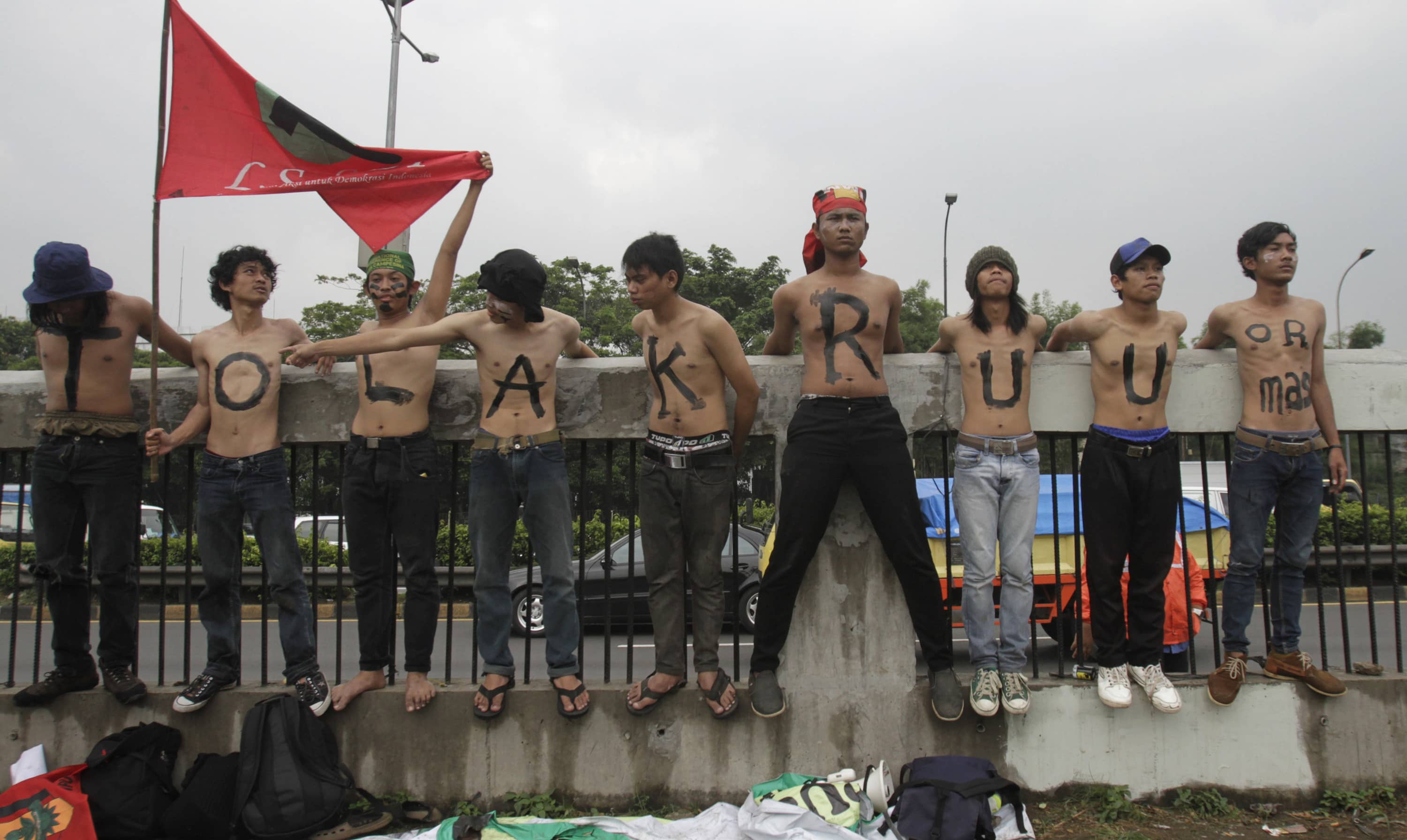 Students protest outside the parliament building in Jakarta, while parliament members hold a meeting to pass the mass organization bill, 2 July 2013; the words on the students' chests read, "reject the mass organization bill", REUTERS/Supri