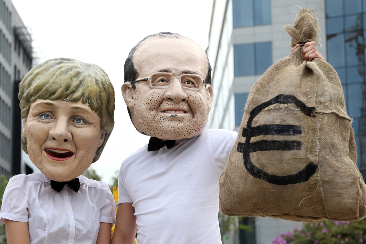 Activists wearing masks depicting German Chancellor Angela Merkel (L) and former French President Francois Hollande stage a tax-related protest outside a meeting of European finance ministers in Brussels, 6 May 2014, REUTERS/Francois Lenoir