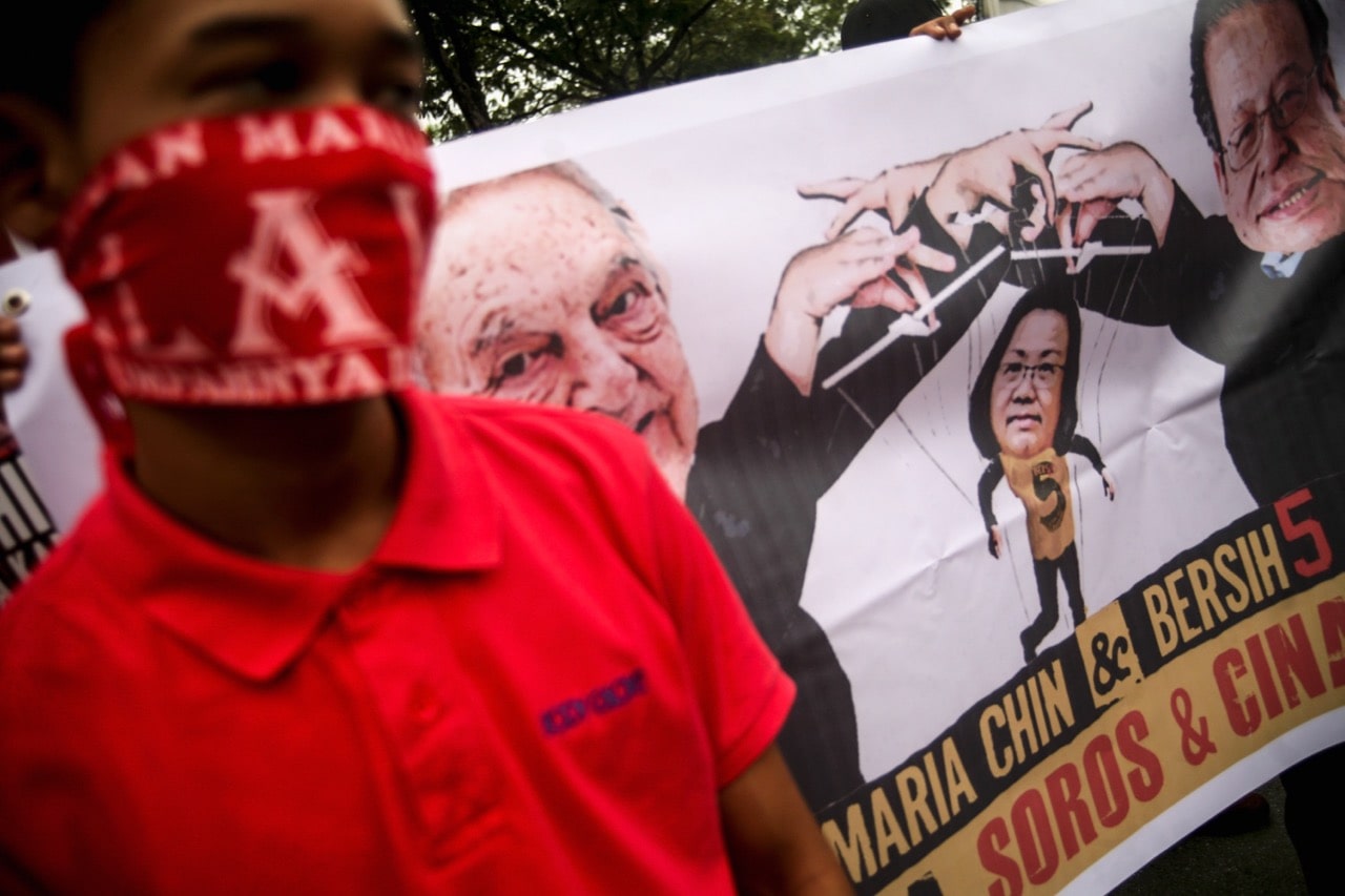 Members of Malaysia's Red Shirt movement call for the Malaysiakini news portal to be closed due to allegations that it is financed by the Open Society Foundation (OSF), which is linked to American billionaire George Soros, during a protest in Kuala Lumpur, 5 November 2016 , Mohd Samsul Mohd Said/Getty Images