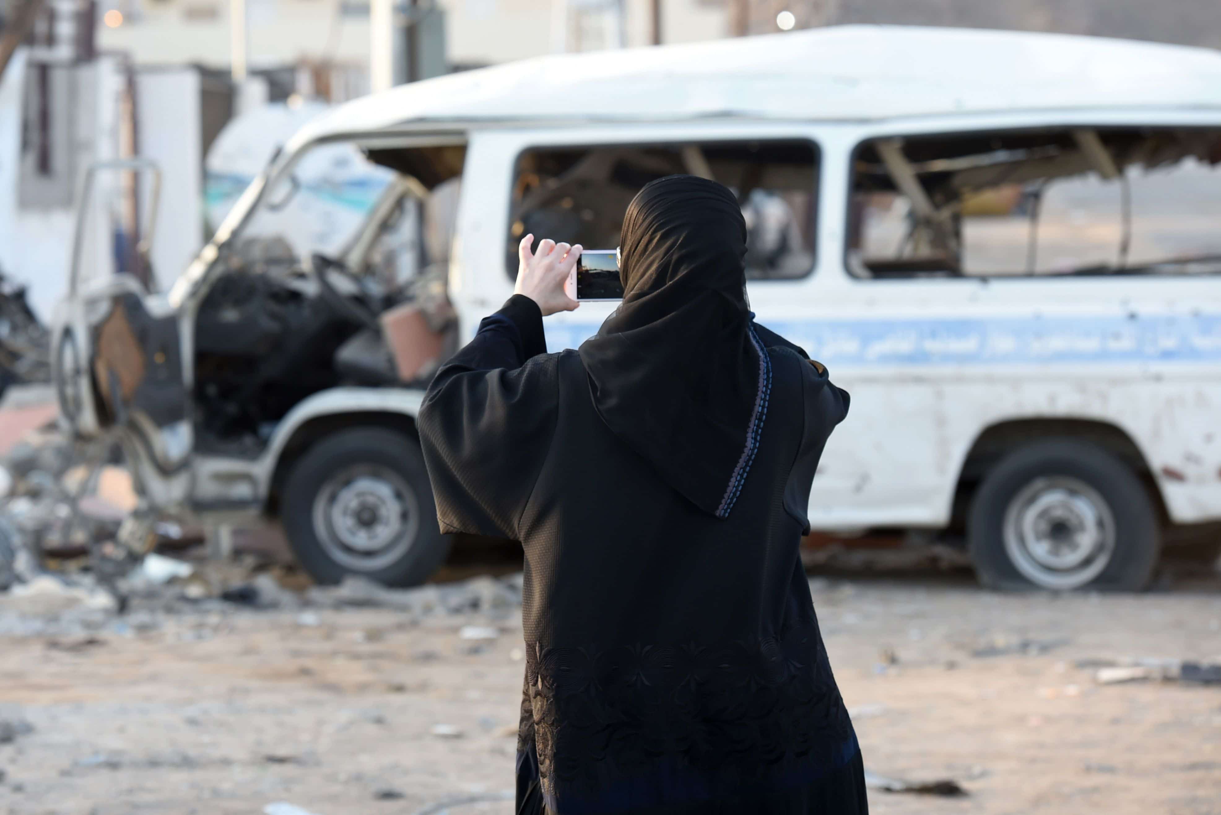 A Saudi female journalist films damage at a market for vehicles in the Saudi border city of Najran, on 27 August 2016, a week after it was struck by a rocket fired from Yemen, FAYEZ NURELDINE/AFP/Getty Images