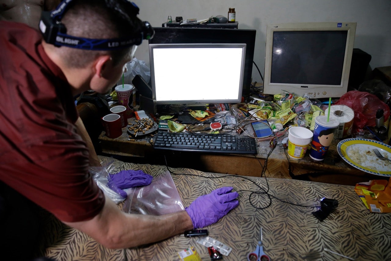 An FBI computer analyst examines the computer of a suspected child webcam cybersex operator from the U.S., during a raid at his home in Mabalacat, Philippines, 20 April 2017, AP Photo/Aaron Favila