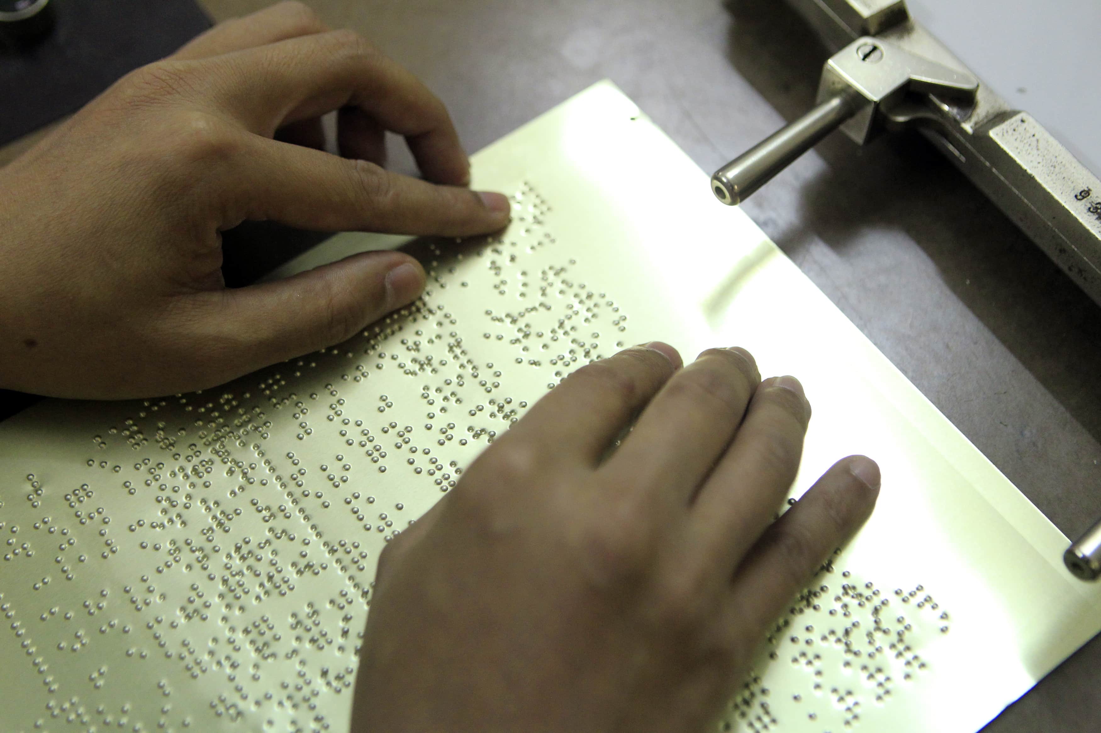 Checking a PhamChecking a Braille press plate for a magazine for the blind in magazine in Hanoi, Vietnam, October 2014, REUTERS/Kham