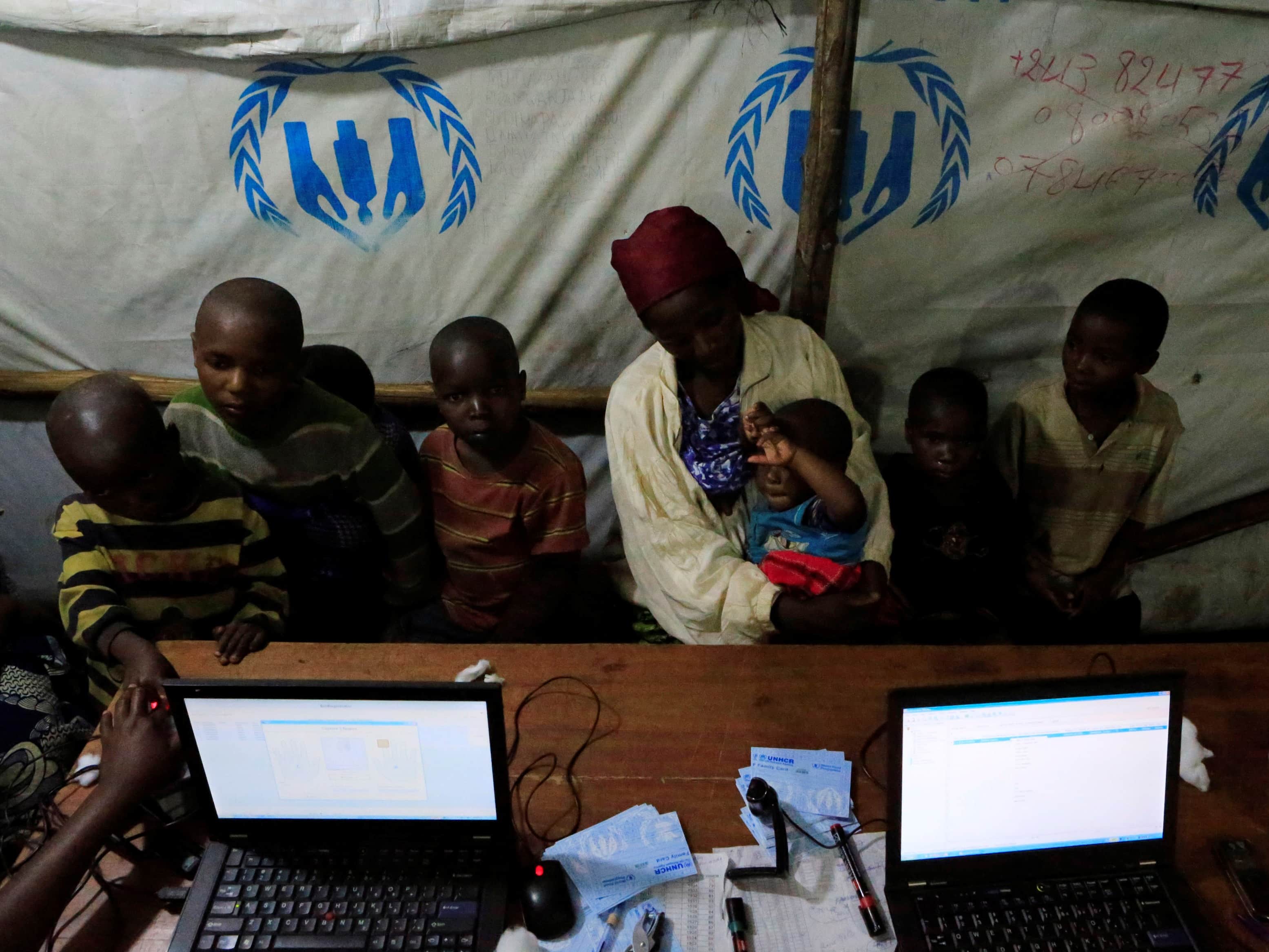 Congolese refugees wait to have their biometric data registered by UNHCR workers at the Nyakabande refugees transit camp in Uganda, 9 November 2013, REUTERS/James Akena