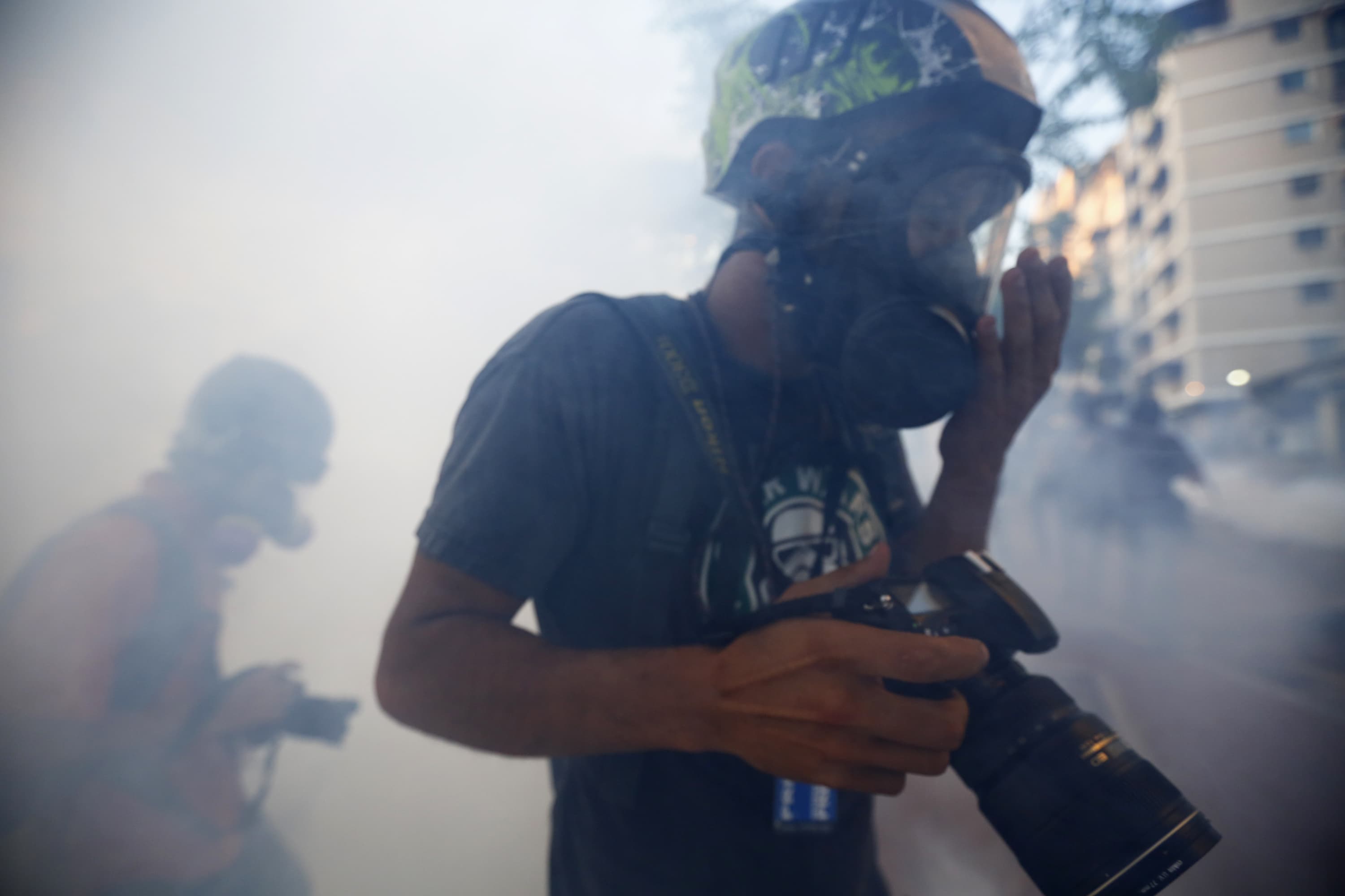 Photographers walk through tear gas during an anti-government protest in Caracas, 2 March 2014, REUTERS/Jorge Silva