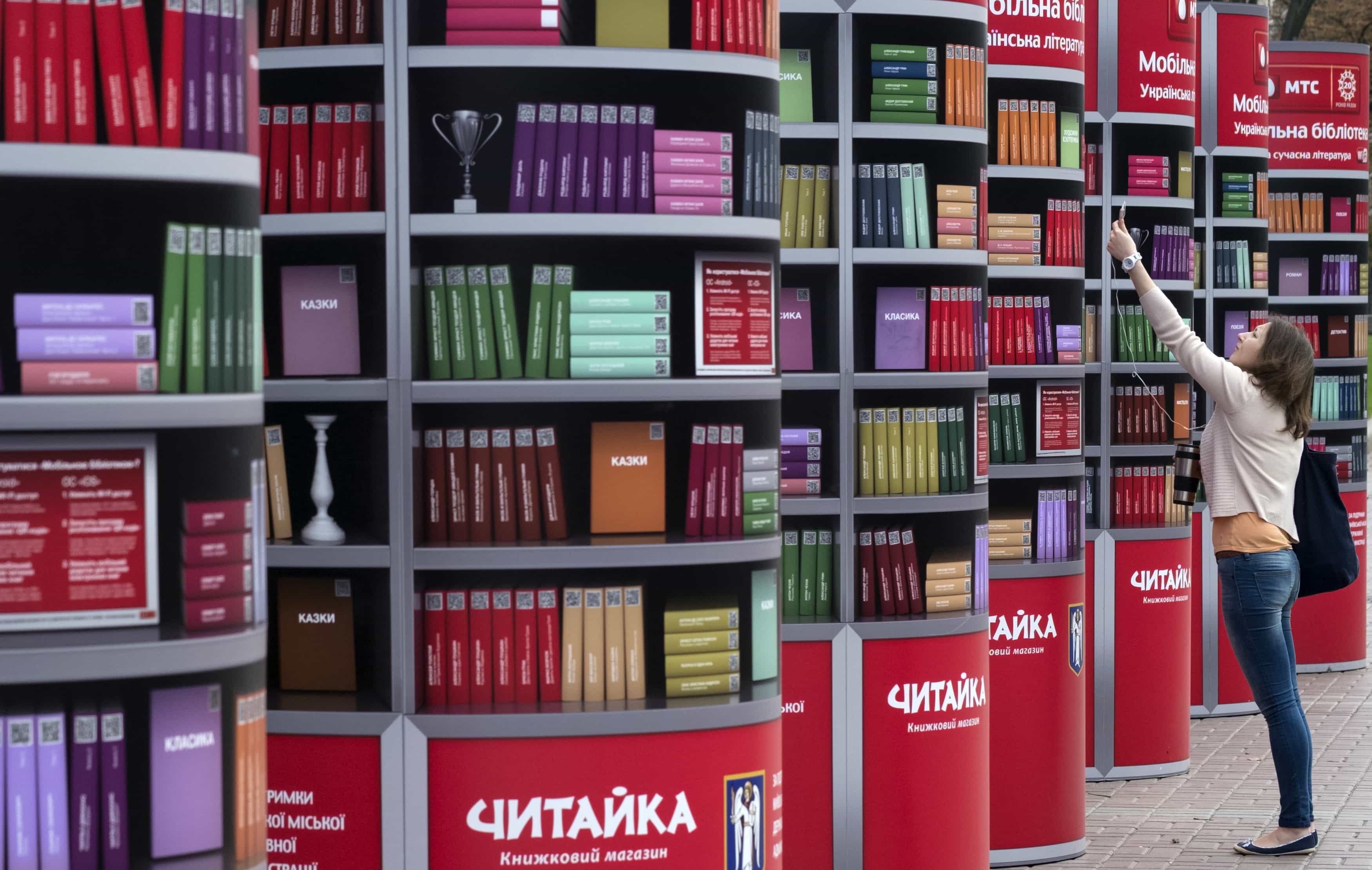 A woman uses her mobile phone to download books in a free mobile library in Kiev, Ukraine, 17 September 2013 , REUTERS/Gleb Garanich