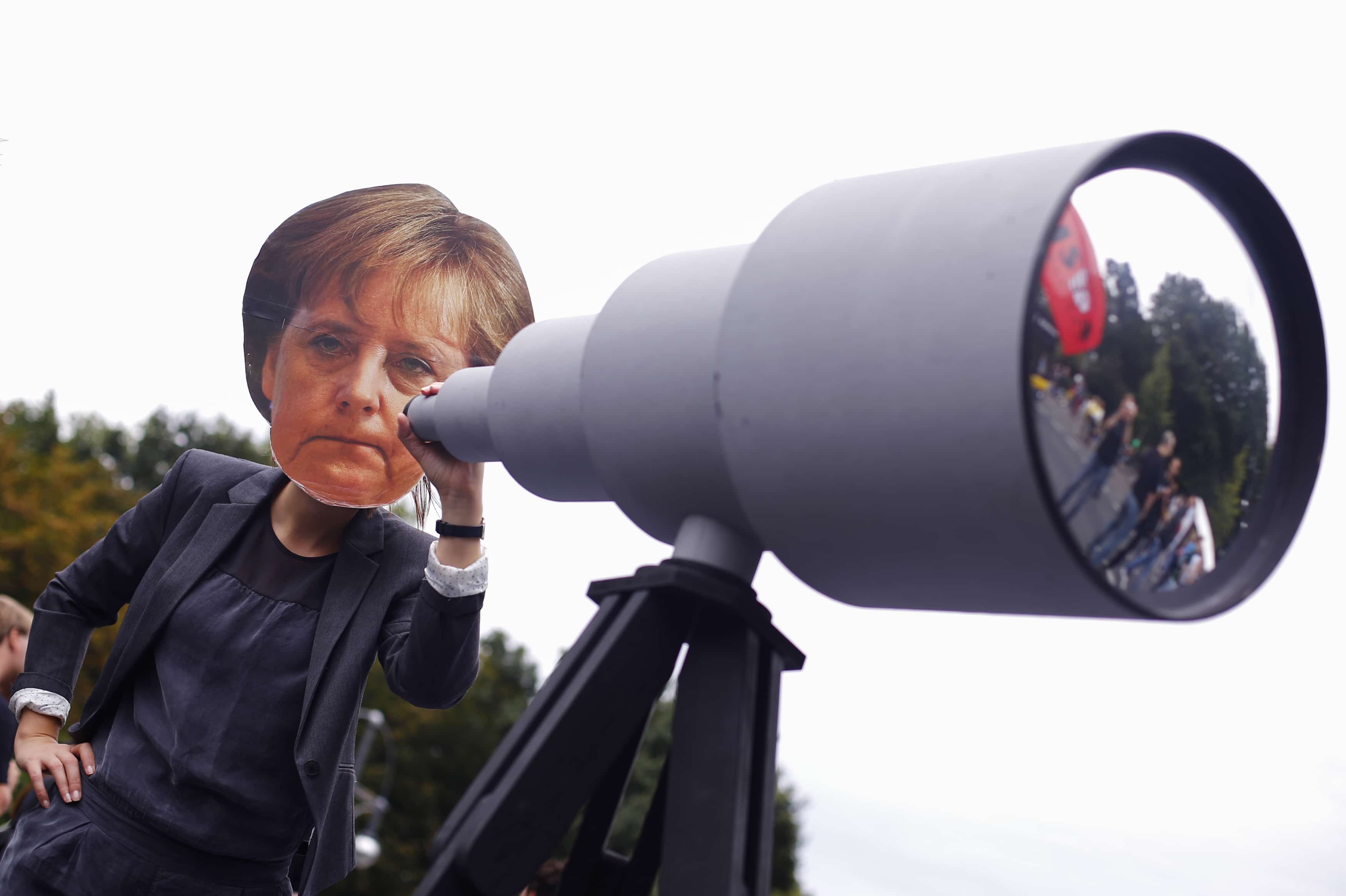 A woman wearing a mask depicting German Chancellor Angela Merkel during a protest in Berlin calling for the protection of digital data privacy, 30 August 2014, REUTERS/Thomas Peter