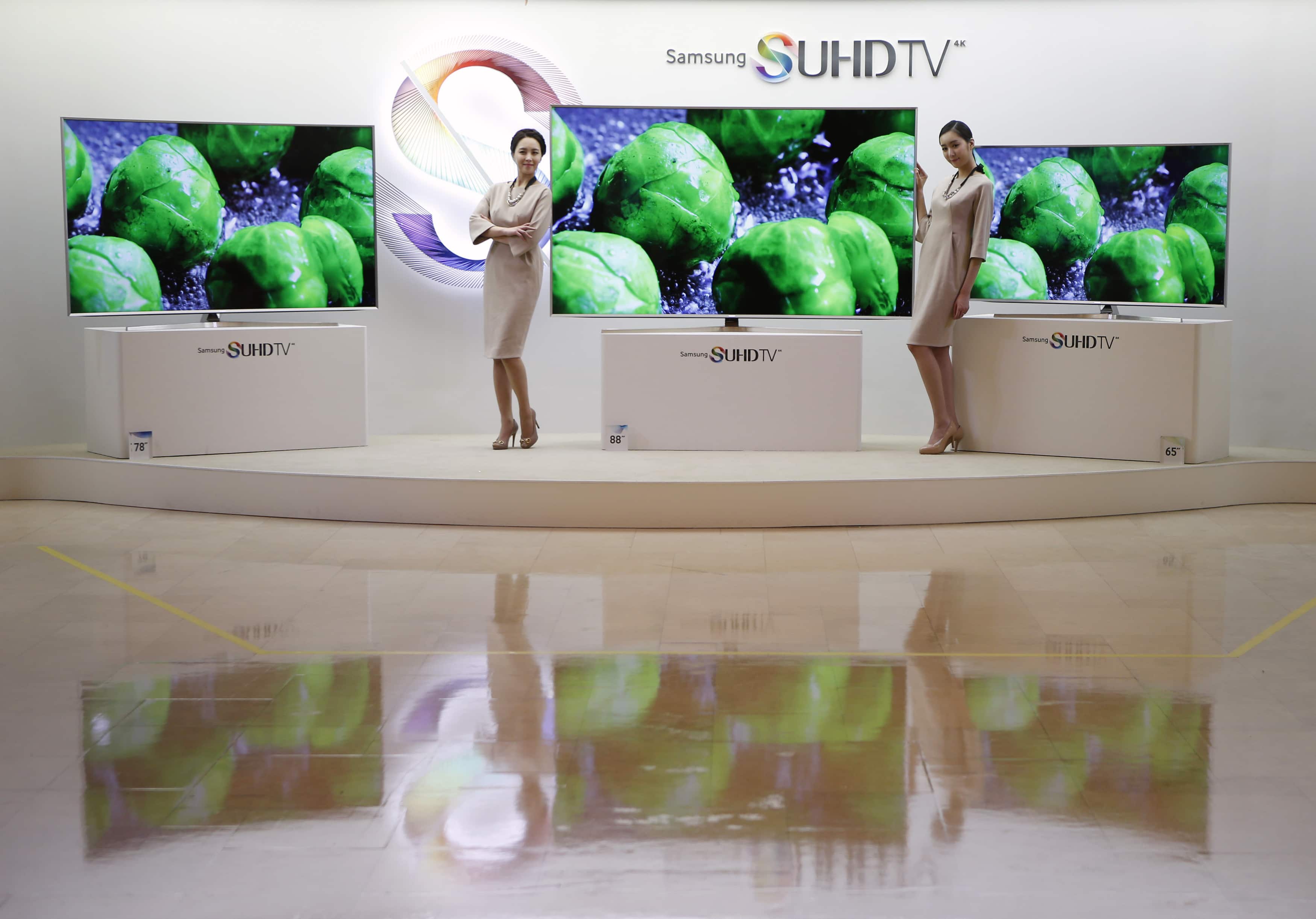 Models pose for photographs next to Samsung Electronics' S'UHD smart television sets during its launch event in Seoul, 5 February 2015, REUTERS/Kim Hong-Ji