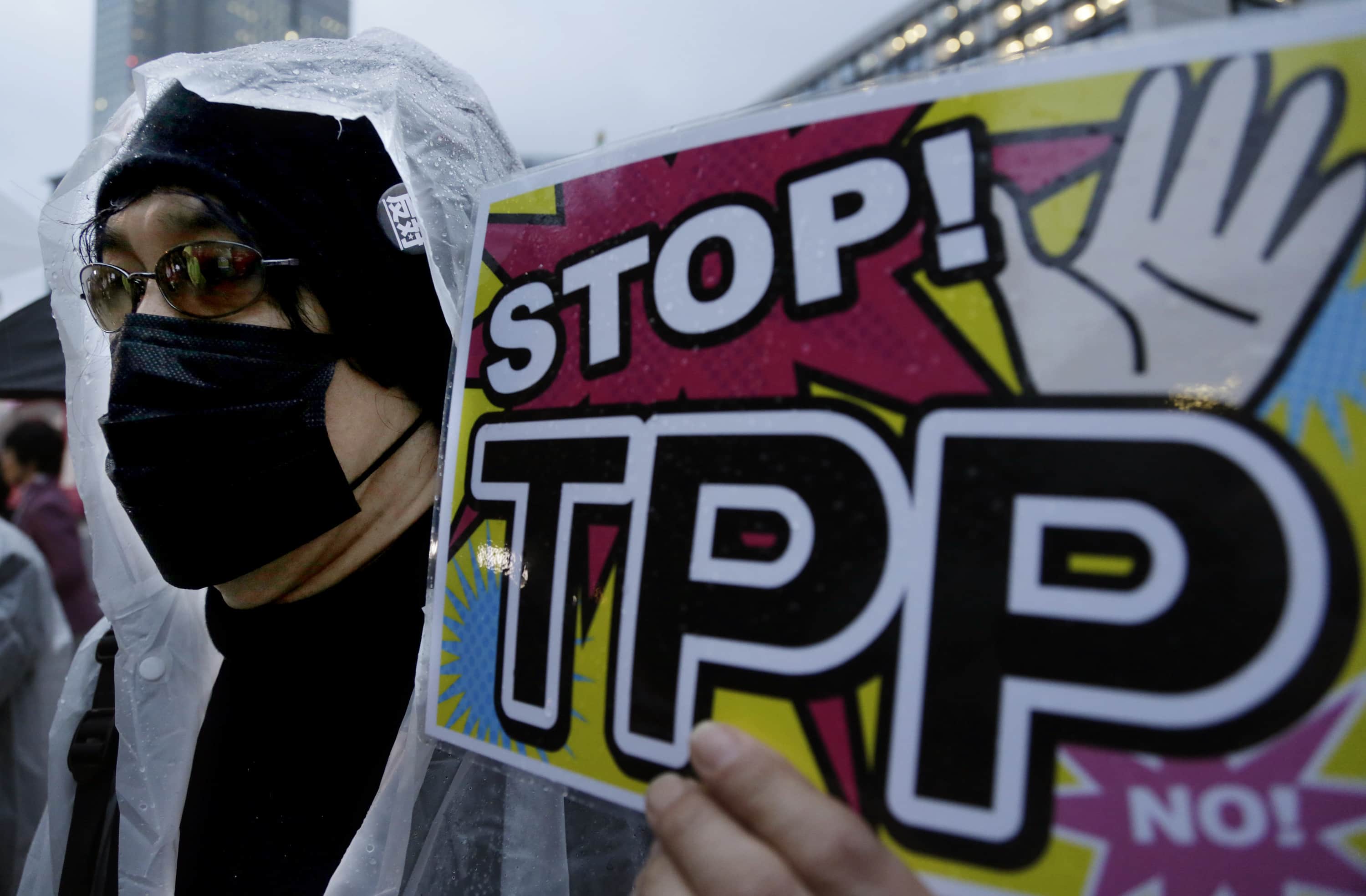 In this April 22, 2014 file photo, a protester holds a placard during a rally against the Trans-Pacific Partnership (TPP) in Tokyo, AP Photo/Shizuo Kambayashi, File