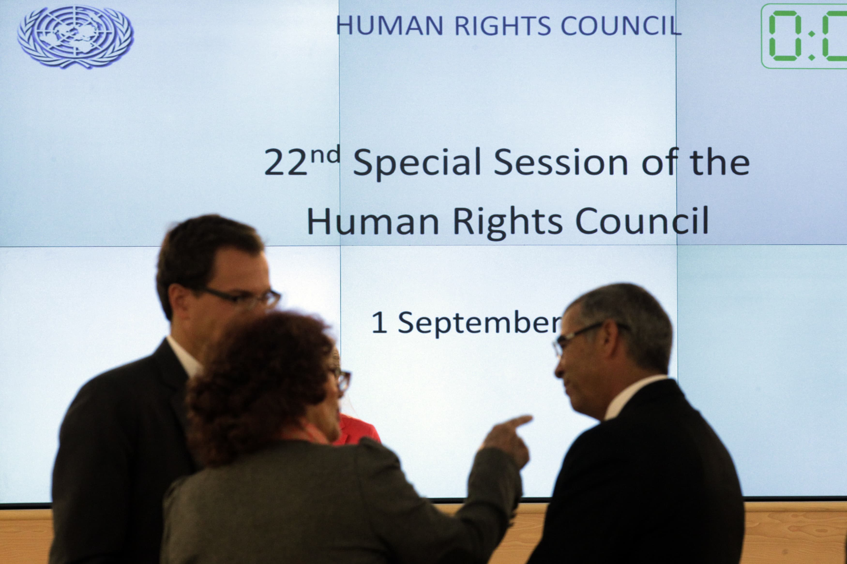 Unidentified delegates talk before a special session of the Human Rights Council on Iraq at the United Nations Europeans headquarters in Geneva, 1 September 2014, REUTERS/Denis Balibouse