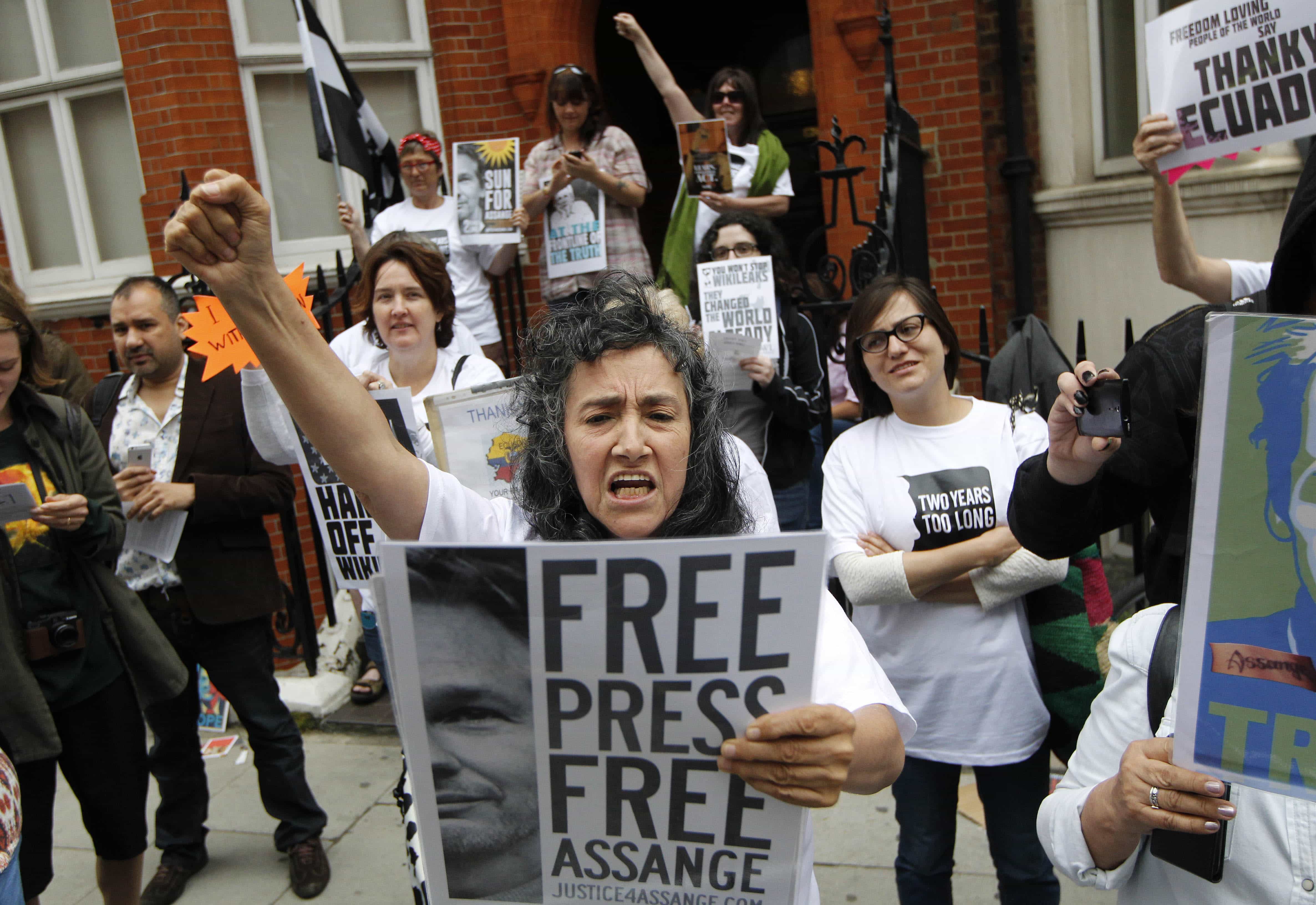 Supporters of WikiLeaks founder Julian Assange hold a vigil outside the Ecuadorian Embassy in London to mark his two years in refuge at the embassy, June 19, 2014, AP Photo/Sang Tan