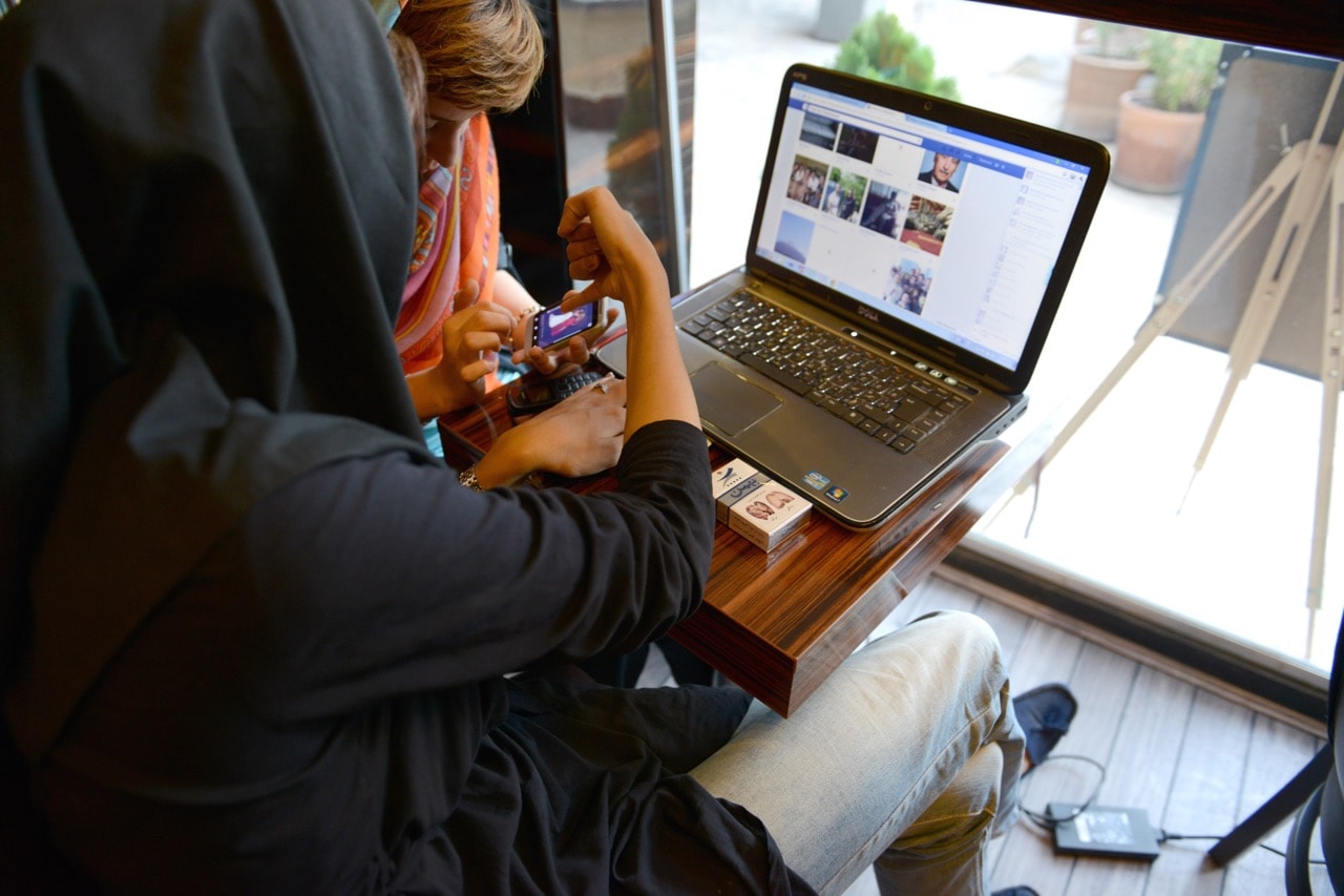 Two women look at a computer and their mobile phones in a coffee shop in Tehran, Iran, 13 October 2013, Kaveh Kazemi/Getty Images