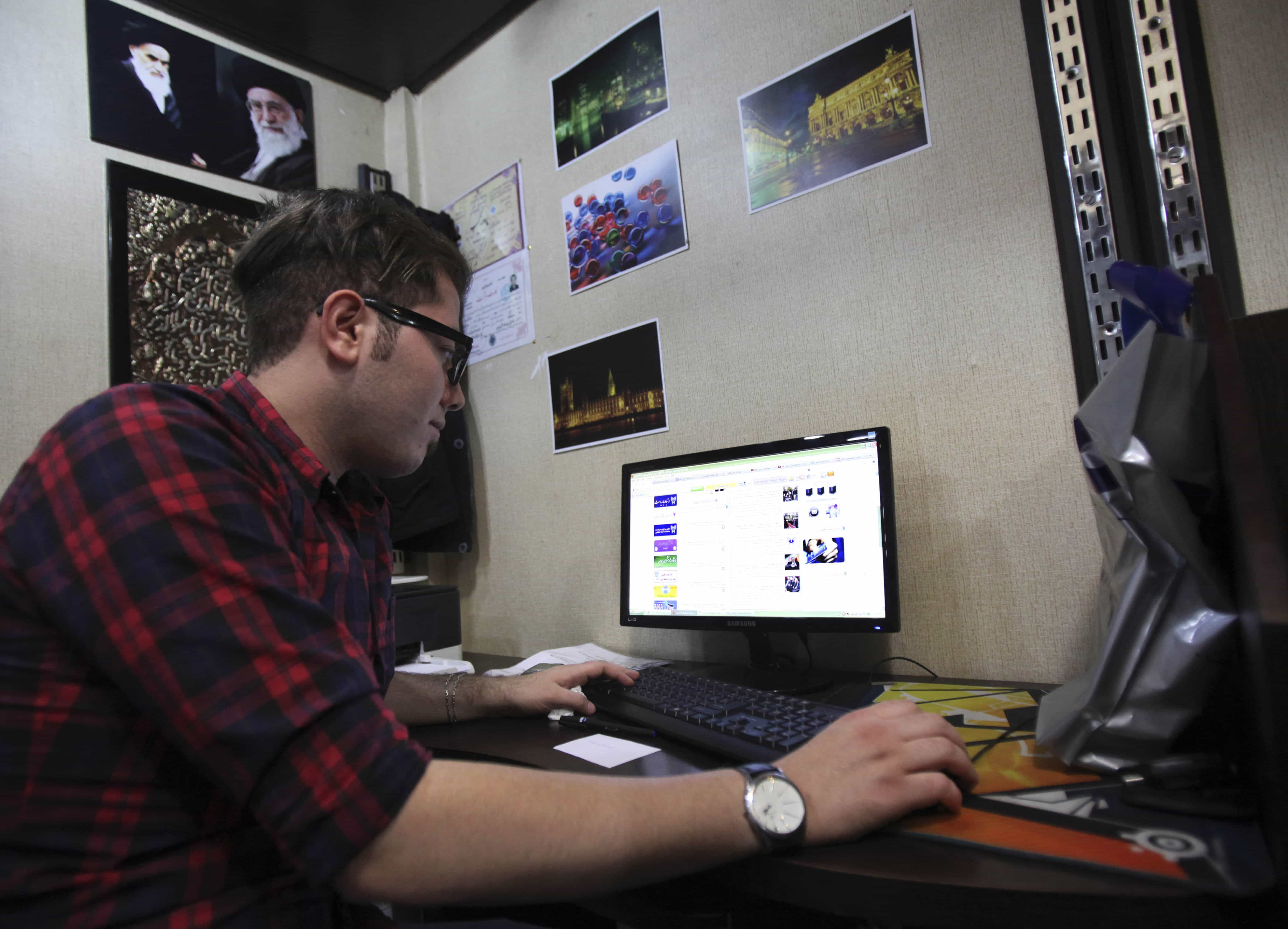 In this file photo taken Sunday, Jan. 6, 2013, an Iranian man uses a computer in an Internet cafe at a shopping center in central Tehran, Iran, AP Photo/Vahid Salemi, File