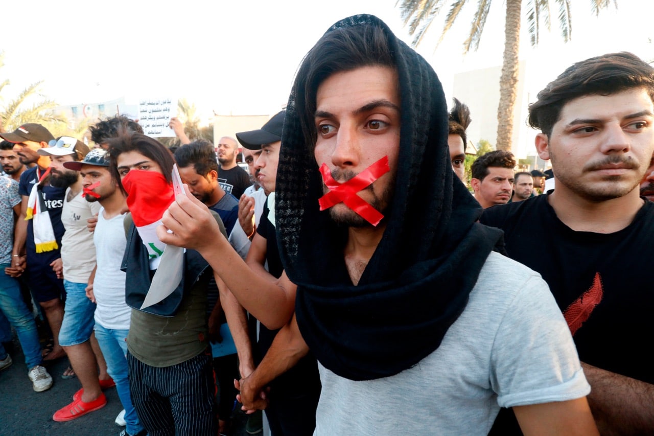 Iraqis with tape on their mouths attend a protest in the southern city of Basra on 24 August 2018, HAIDAR MOHAMMED ALI/AFP/Getty Images