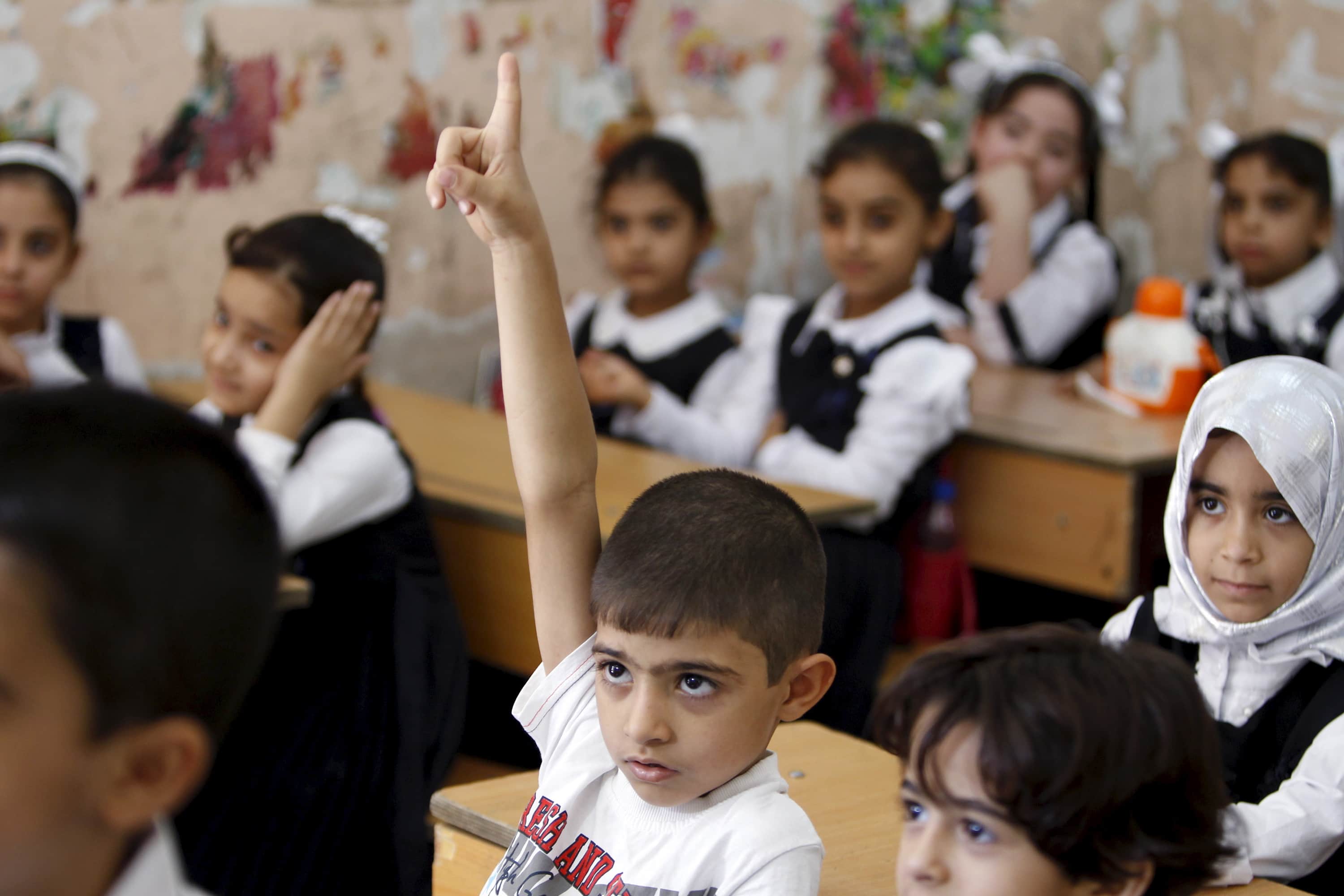 A student raises his hand while attending the first day of the new school term at a primary school in Baghdad, October 18, 2015, REUTERS/Ahmed Saad