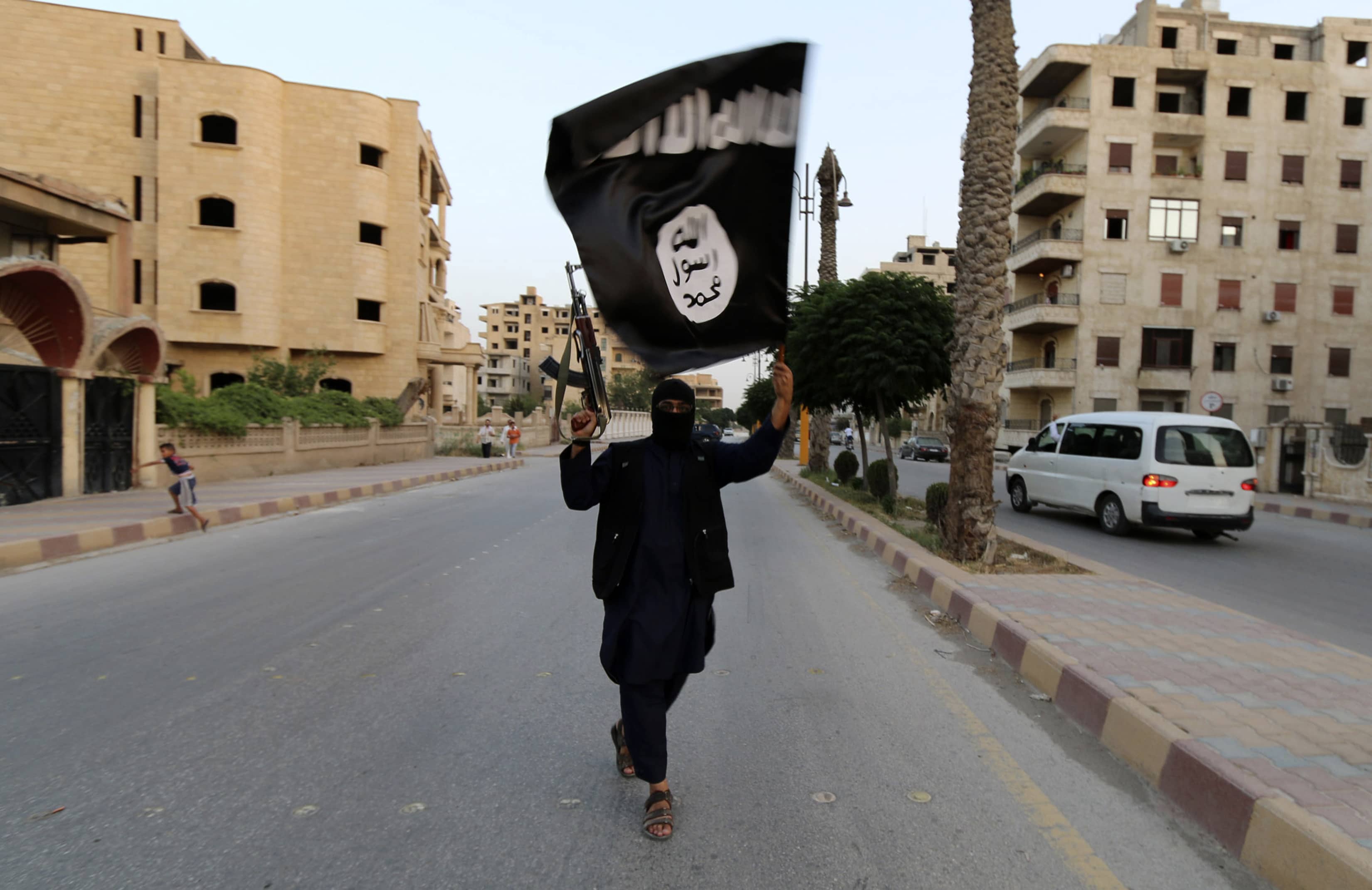 A member loyal to the Islamic State in Iraq and the Levant (ISIL) waves an ISIL flag in Raqqa on 29 June 2014, REUTERS/Stringer