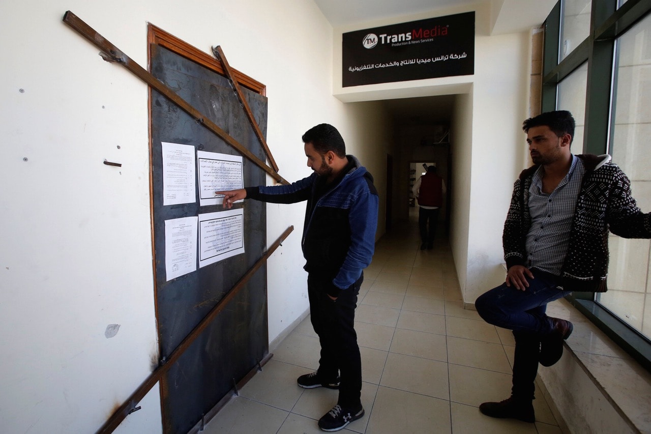 Palestinians check the entrance of Transmedia company after it was closed by the Israeli army in the West Bank city of Hebron, 18 October 2017, REUTERS/Mussa Qawasma