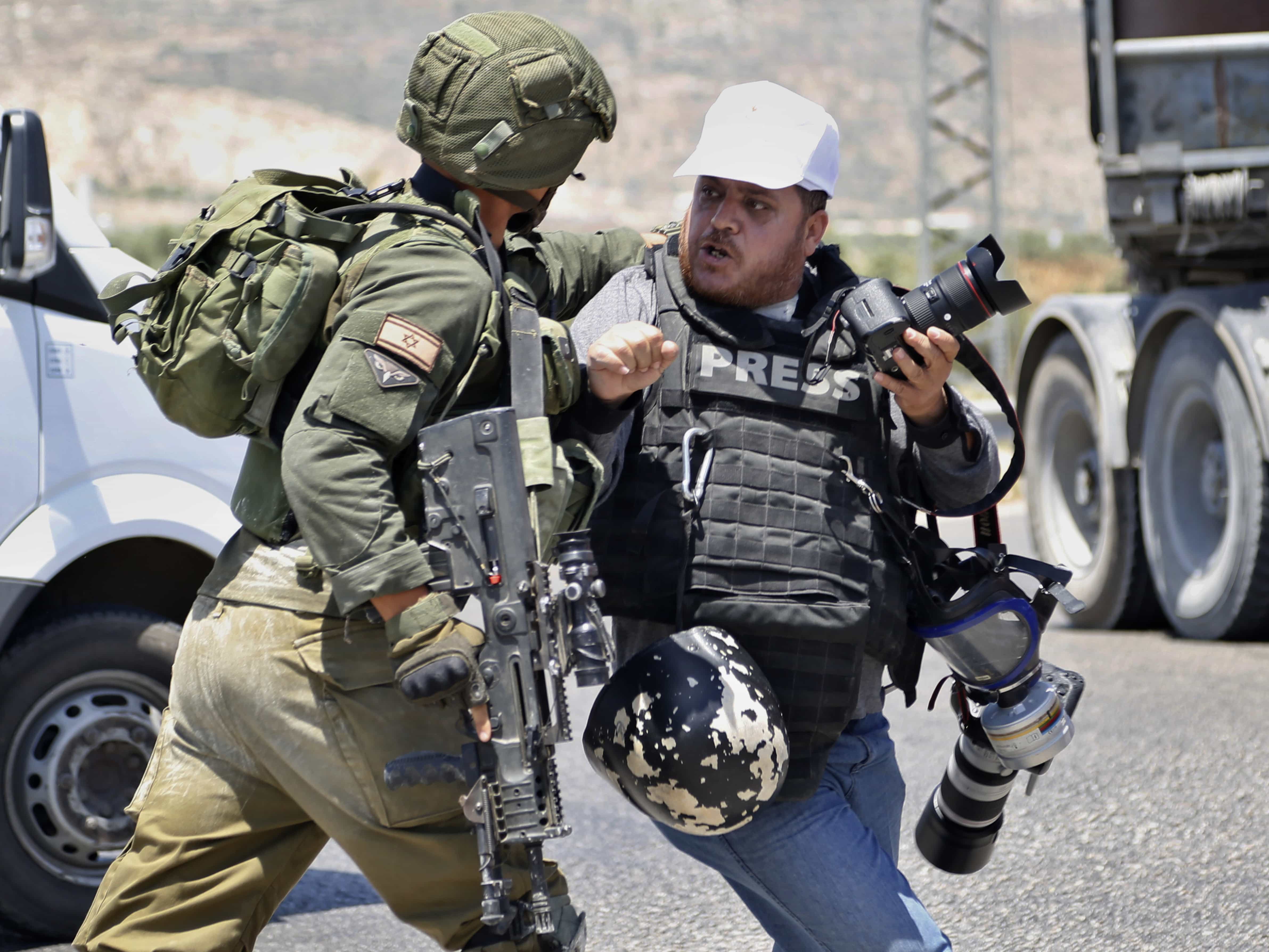 An Israeli soldier pushes a Palestinian photojournalist during a protest in solidarity with Palestinian prisoners on hunger strike in Israeli jails near the settlement of Shavei Shamron close to the West Bank city of Nablus, 16 May 2017, AP Photo/Majdi Mohammed