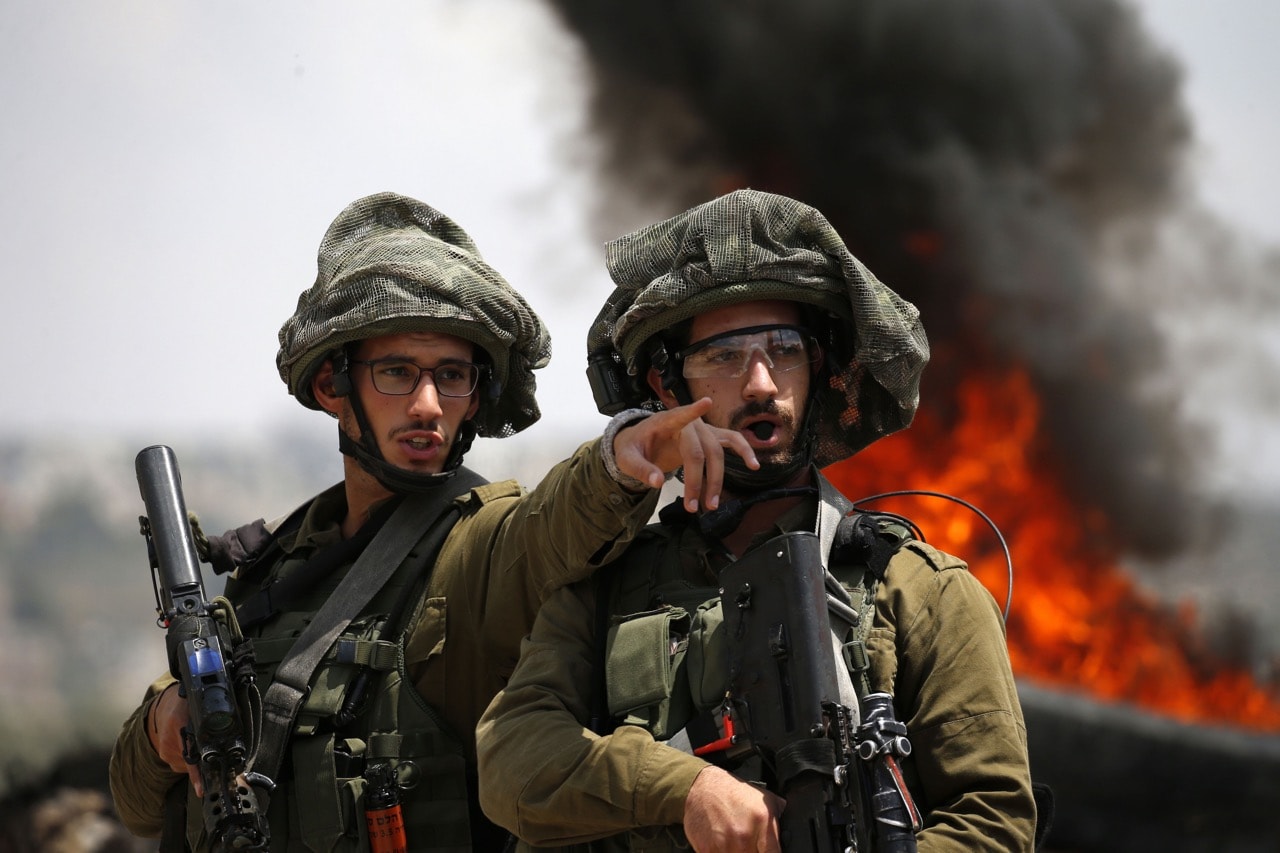Israeli soldiers talk during clashes with Palestinian protesters in the village of Kfar Qaddum, near Nablus in the occupied West Bank, 1 June 2018, JAAFAR ASHTIYEH/AFP/Getty Images