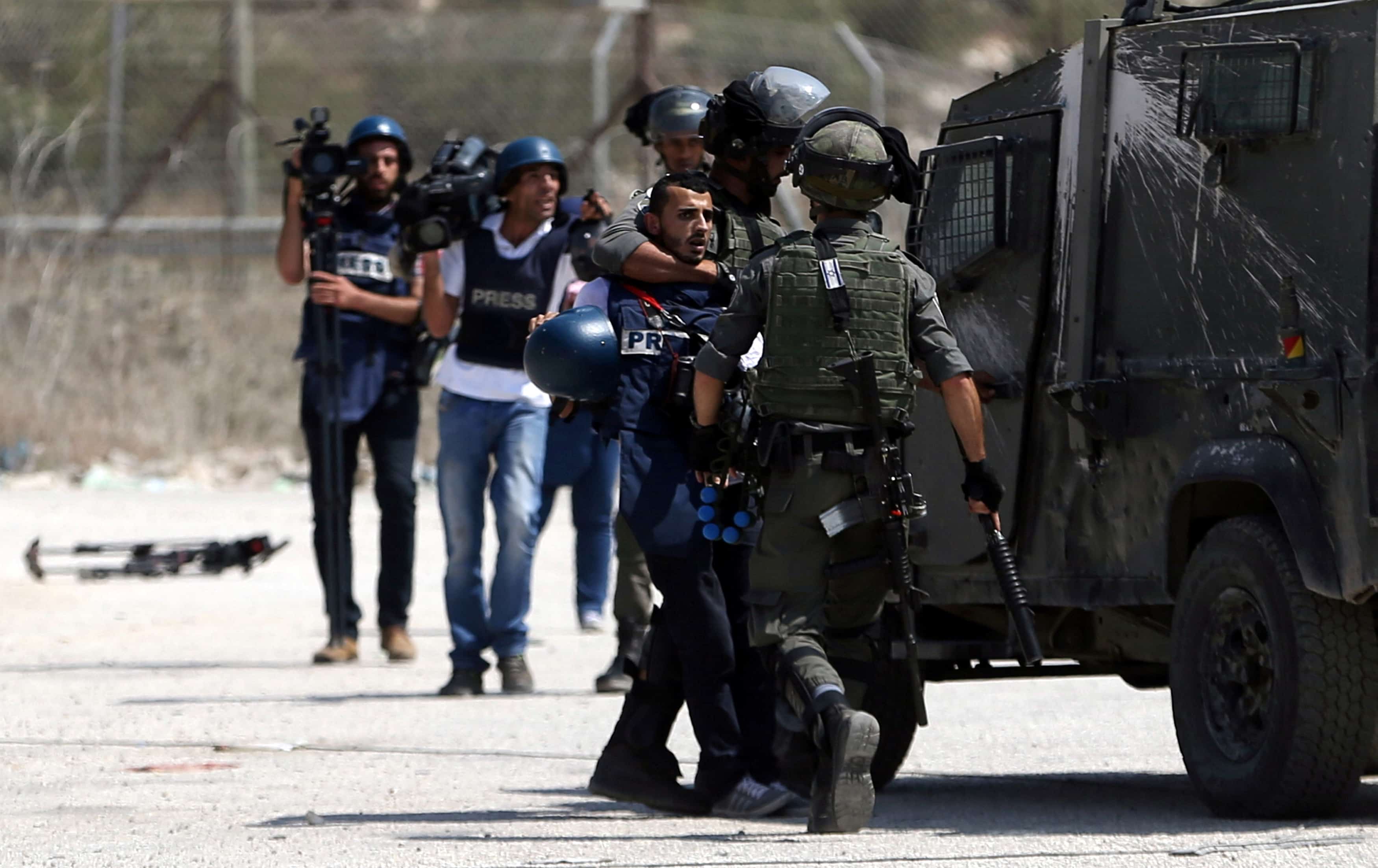 Israeli border policemen detain a Palestinian journalist during clashes with Palestinian protesters near Israel's Ofer Prison near the West Bank city of Ramallah August 3, 2016.,  REUTERS/Mohamad Torokman