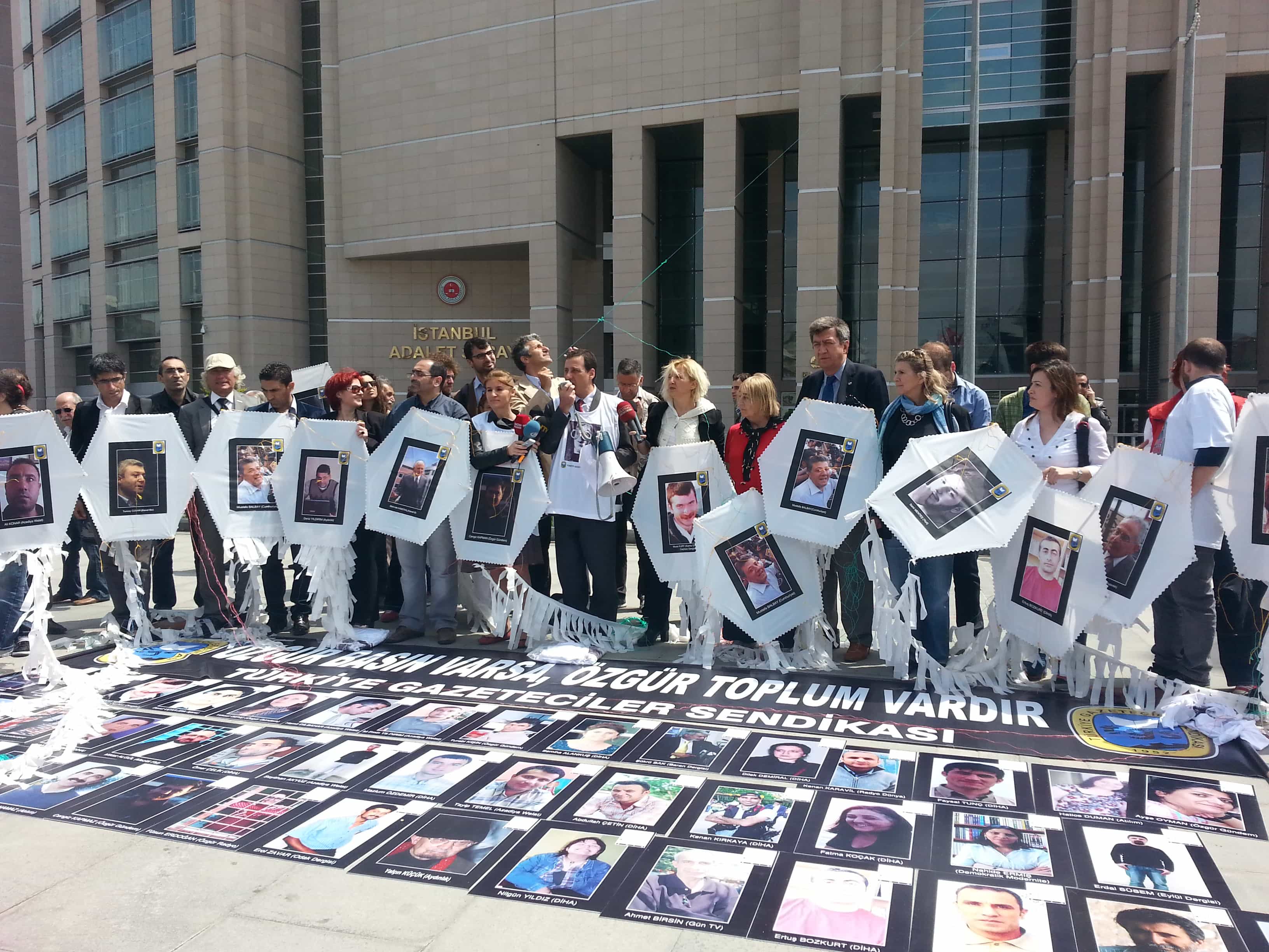 Media freedom advocates hold kites with photos of 62 jailed journalists in front of the court in Istanbul., Şanar Yurdatapan/Initiative for Freedom of Expression