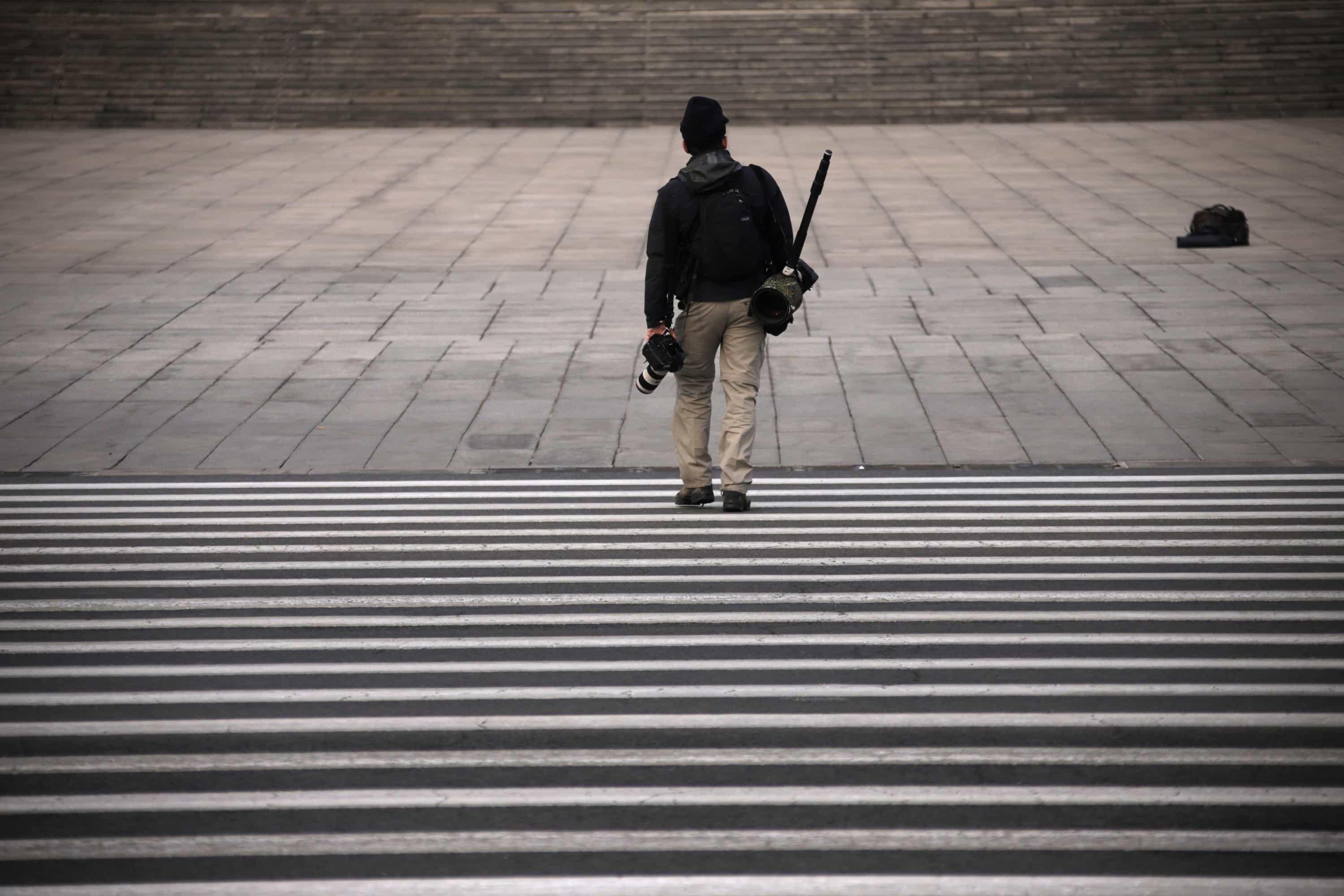 A journalist carrying cameras walks away, REUTERS/Petar Kujundzic