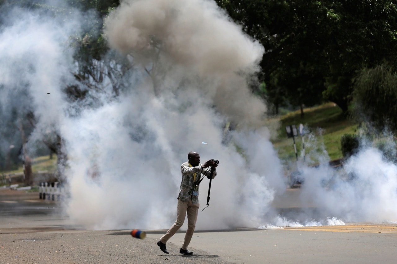 A journalists runs past a cloud of tear gas after riot police dispersed anti-corruption protesters during a demonstration in Nairobi, Kenya, 3 November 2016, REUTERS/Thomas Mukoya