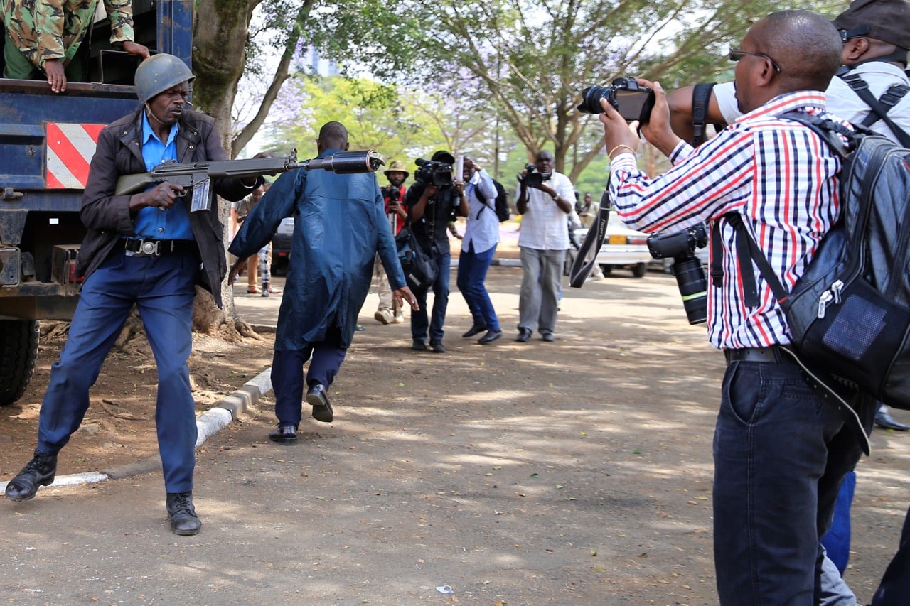 A riot policeman attempts to fire a tear-gas canister towards journalists covering anti-corruption protests in Nairobi, Kenya, 3 November 2016, REUTERS/Thomas Mukoya