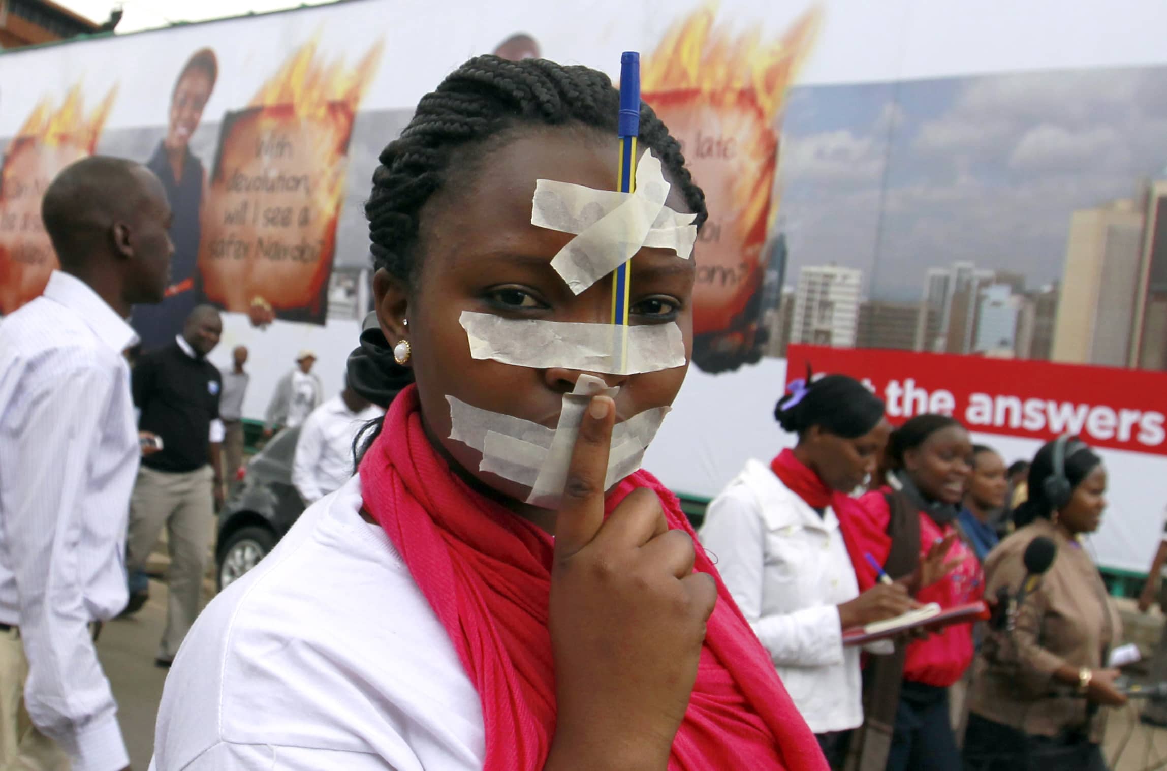 A Kenyan journalist participates in a protest with tape over her mouth and a pen on her forehead along the streets of the capital Nairobi, 3 December 2013., REUTERS/Thomas Mukoya