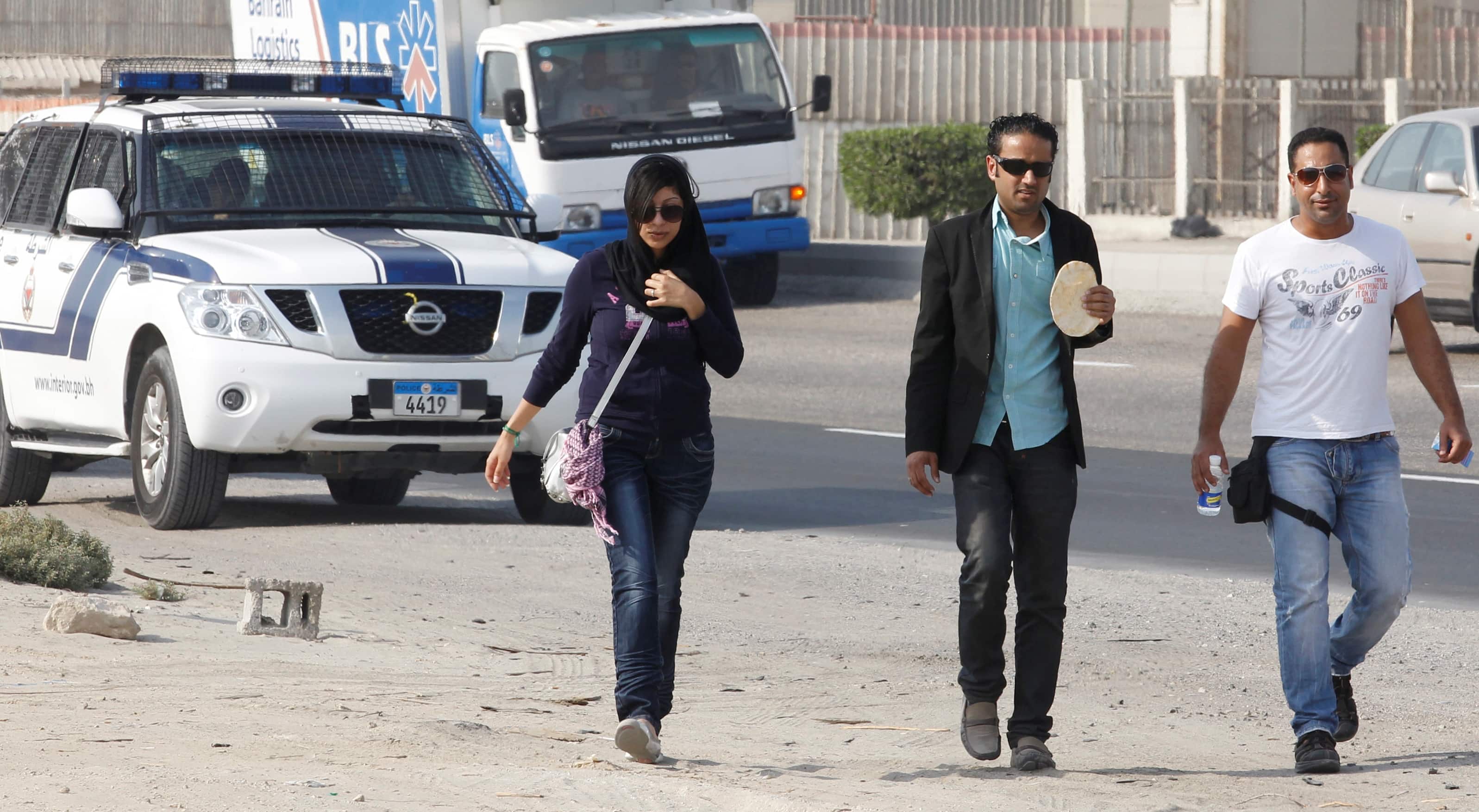 Human rights activists Zaynab al-Khawaja (L), Yousif al-Mahafdhah (C) and Naji Fateel march towards al-Eker village before being detained by police, south of Manama on 21 October 2012, REUTERS/Hamad Mohammed