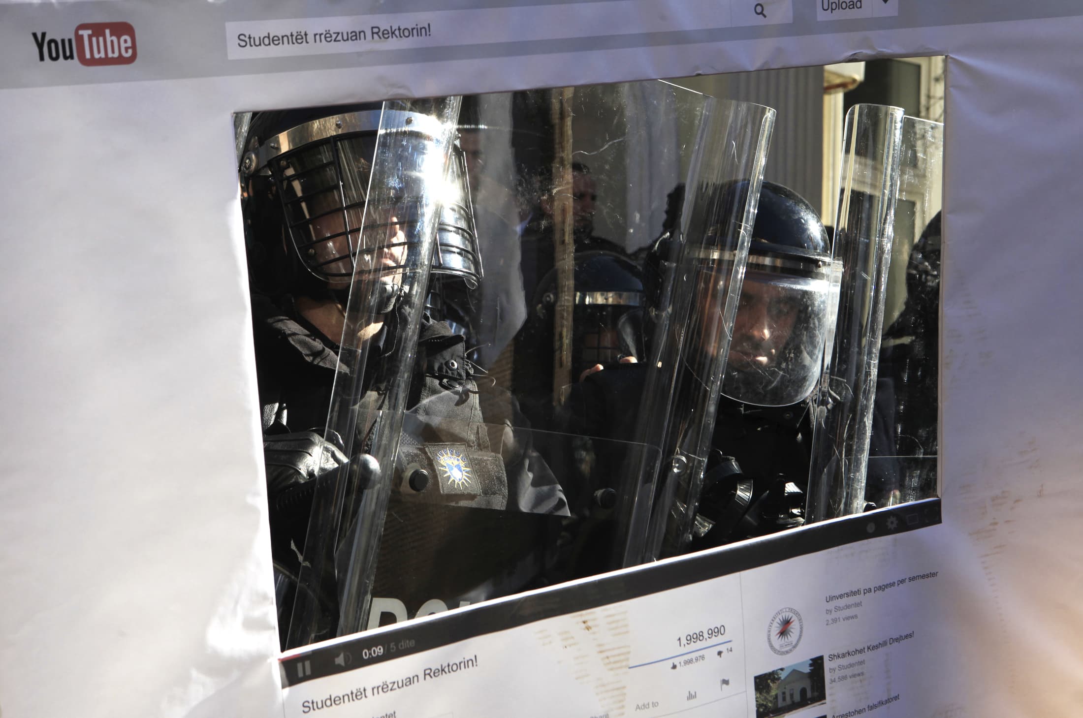 Police officers are seen through a cut-out depicting a YouTube page, during a clash with students, at the University of Pristina, Kosovo, 3 February 2014., REUTERS/Hazir Reka