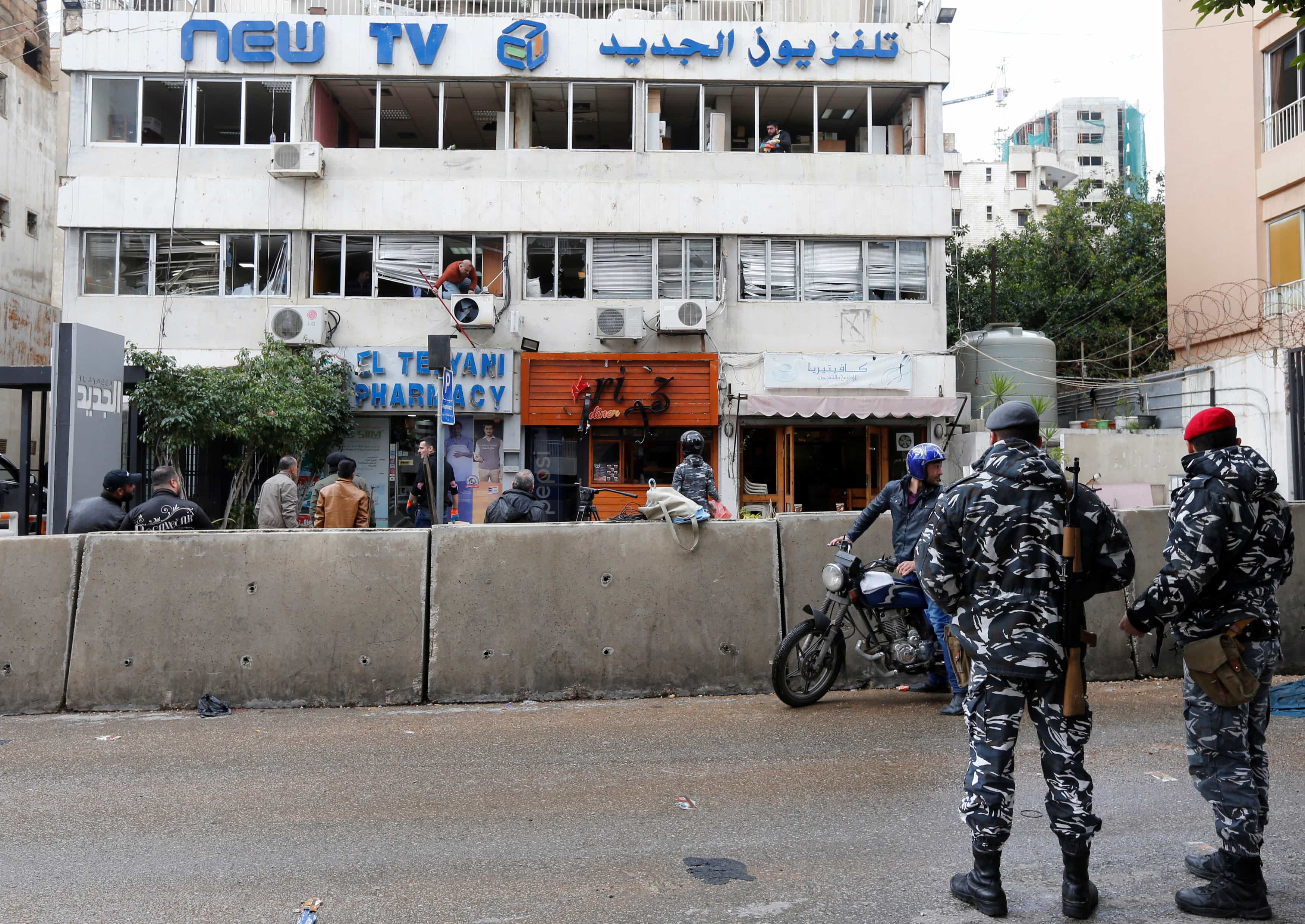 Policemen stand guard as workers remove broken glass from the headquarters of Lebanese television channel al-Jadeed, after demonstrators attacked the channel's headquarters on Tuesday, in Beirut, Lebanon February 15, 2017, REUTERS/Mohamed Azakir