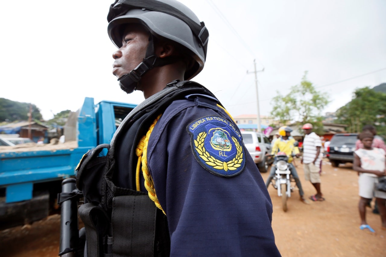 A Liberian National Police officer stands guard during aid delivery from Liberia to Sierra Leone, at Regent, Sierra Leone, 19 August 2017, REUTERS/Afolabi Sotunde