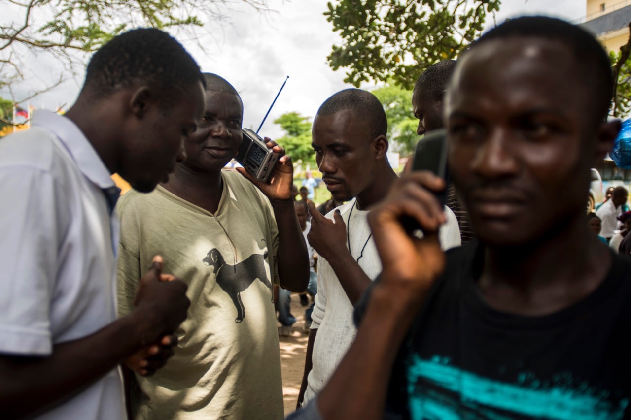 Liberians listen to the radio for the results of the presidential ballot, in Monrovia, 13 October 2017, CRISTINA ALDEHUELA/AFP/Getty Images