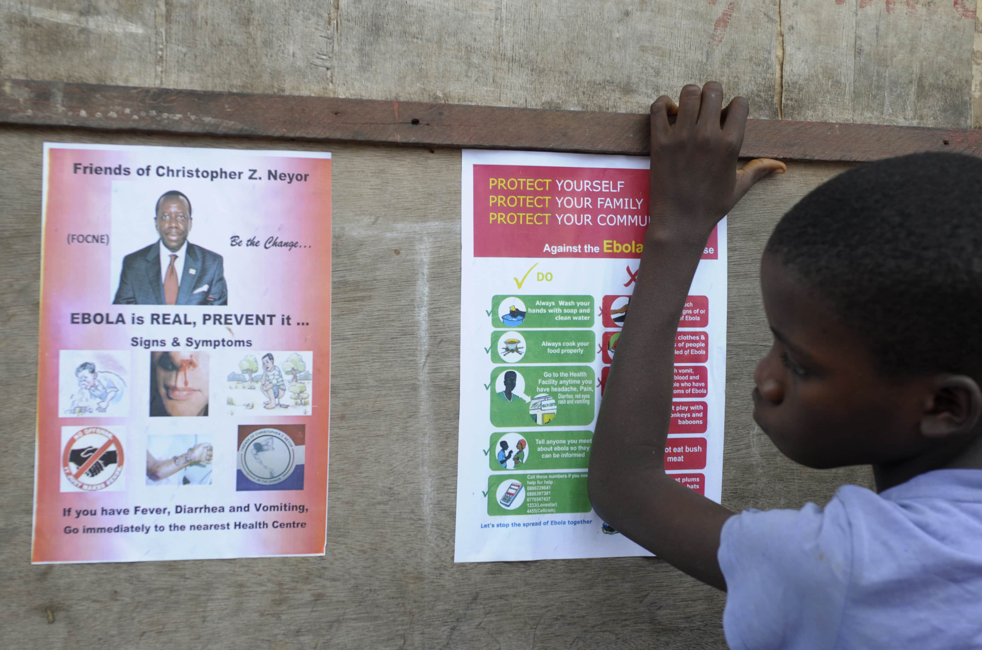 A boy stands near posters displaying a government message against Ebola at Duwala market in Monrovia, 17 August 2014, REUTERS/2Tango